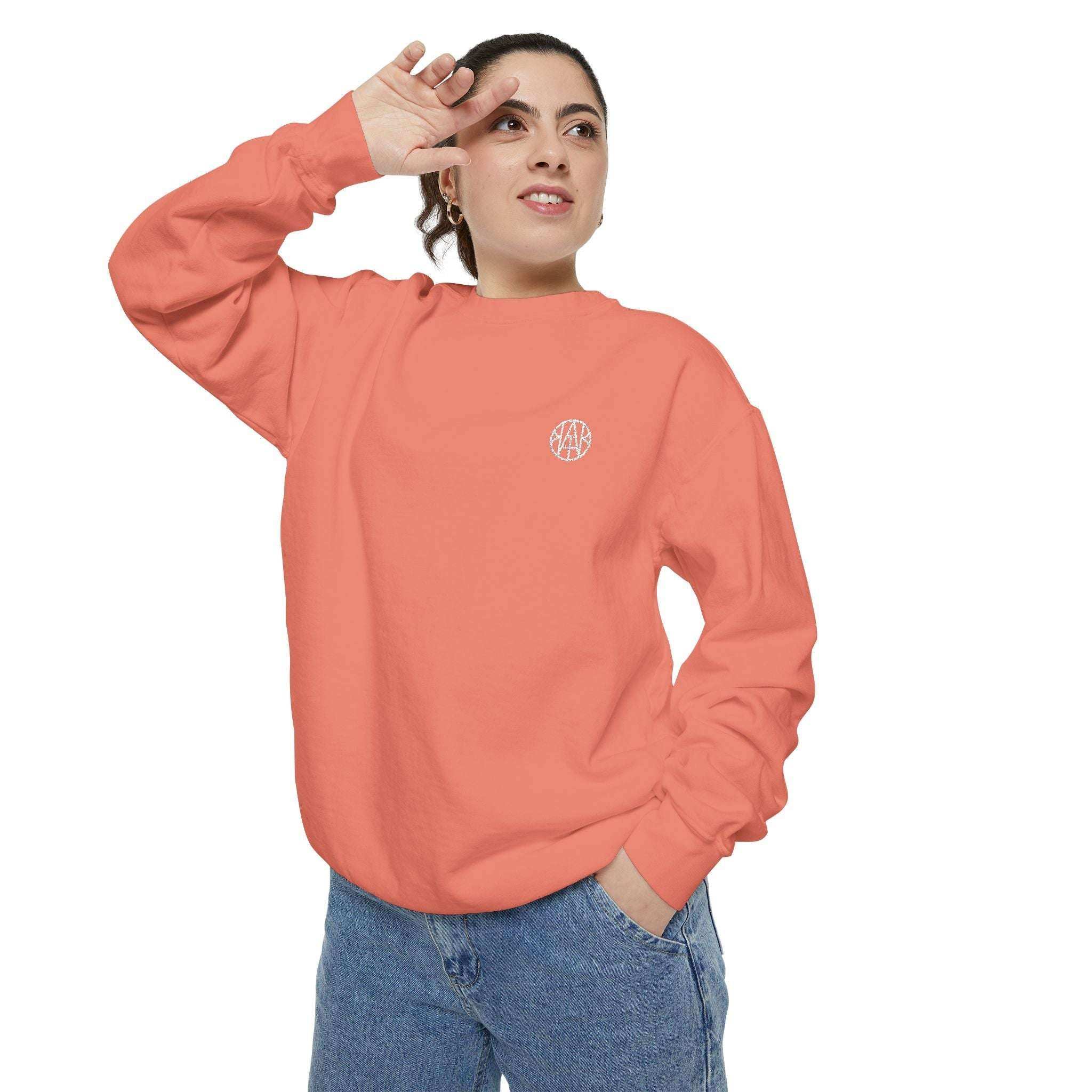 Woman wearing a coral AEMBR sweatshirt with logo, posing against white background