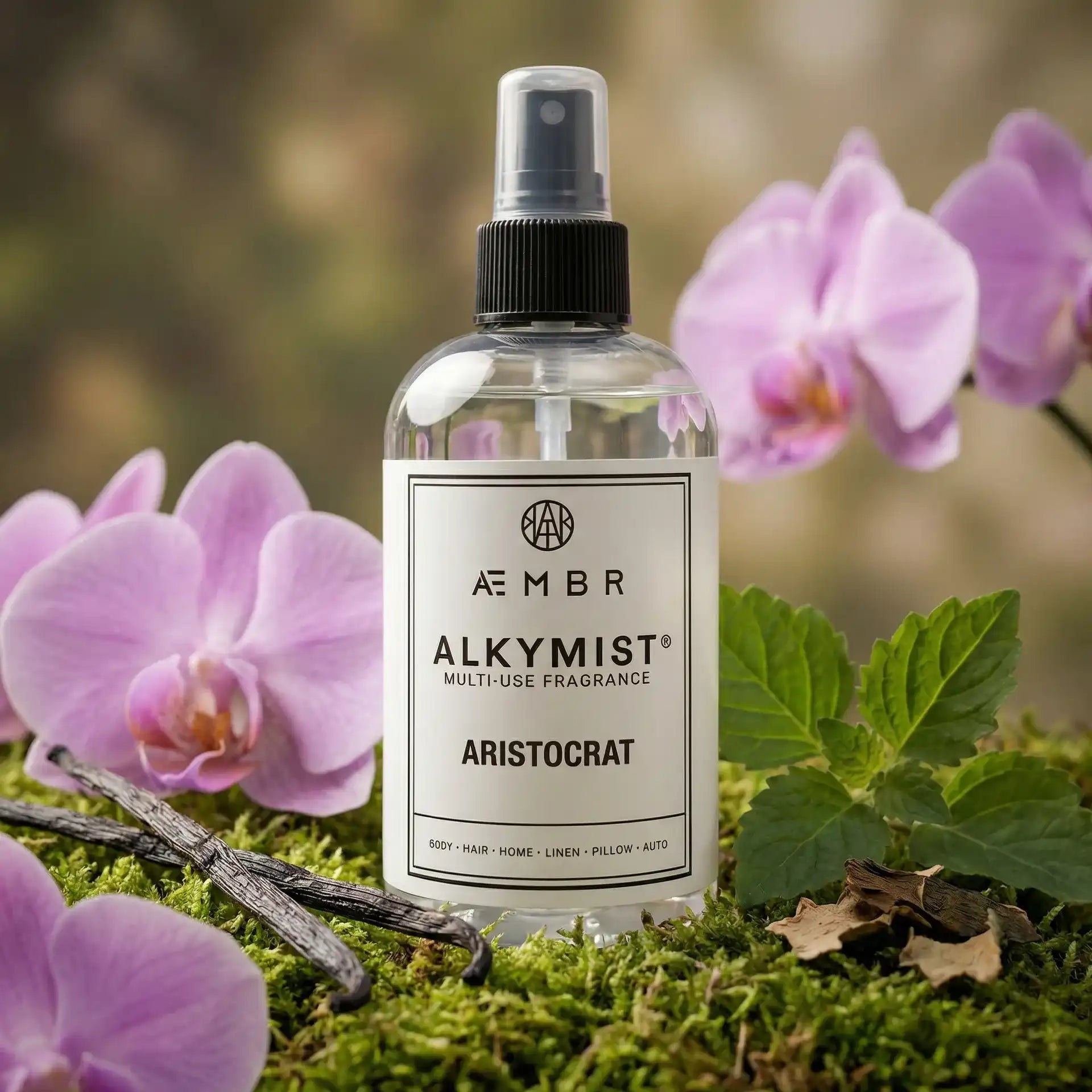 Non-toxic multi-use fragrance spray bottle with vanilla beans, green leaves, and pink orchids
