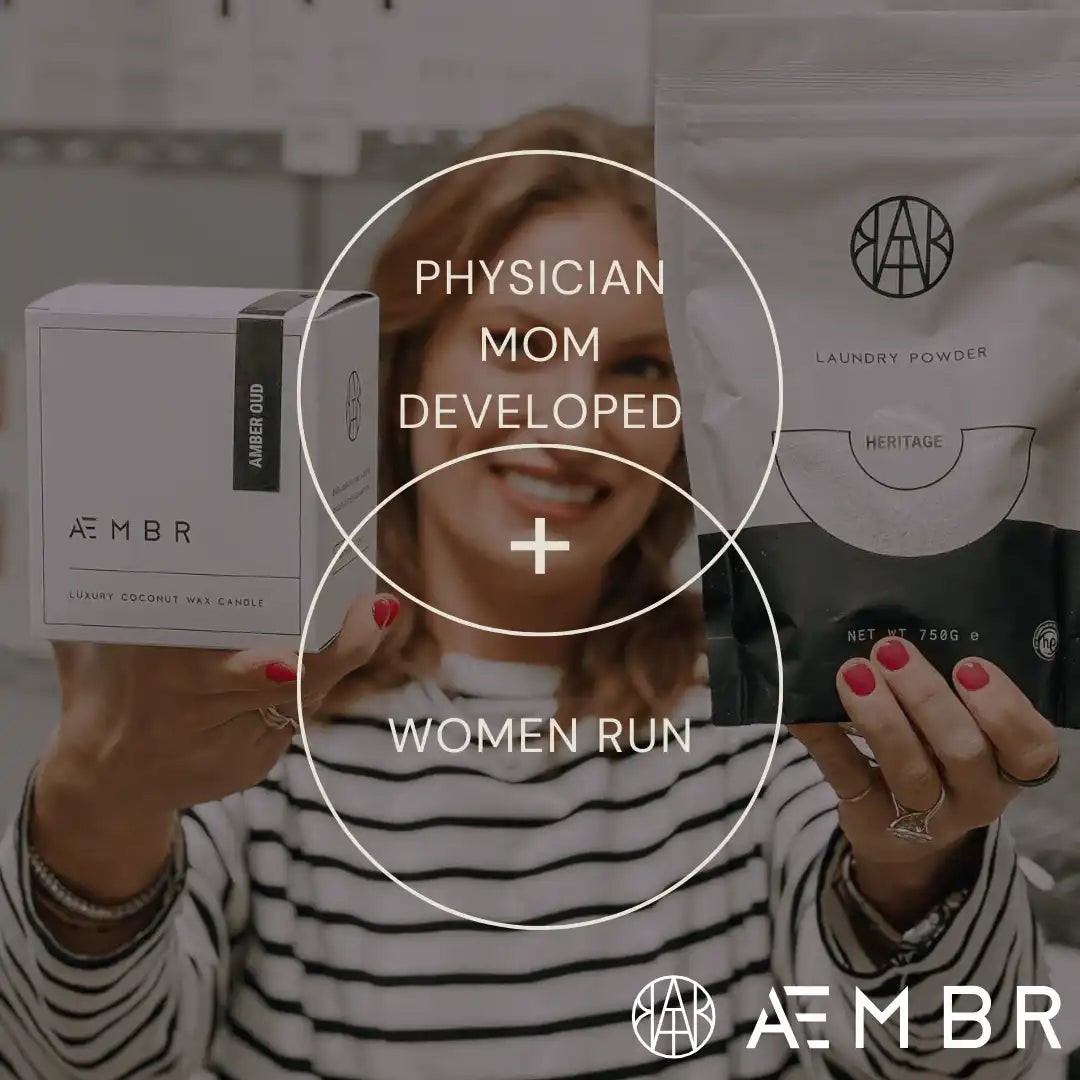 AEMBR luxury coconut wax candle and laundry powder held by smiling woman, women-run brand
