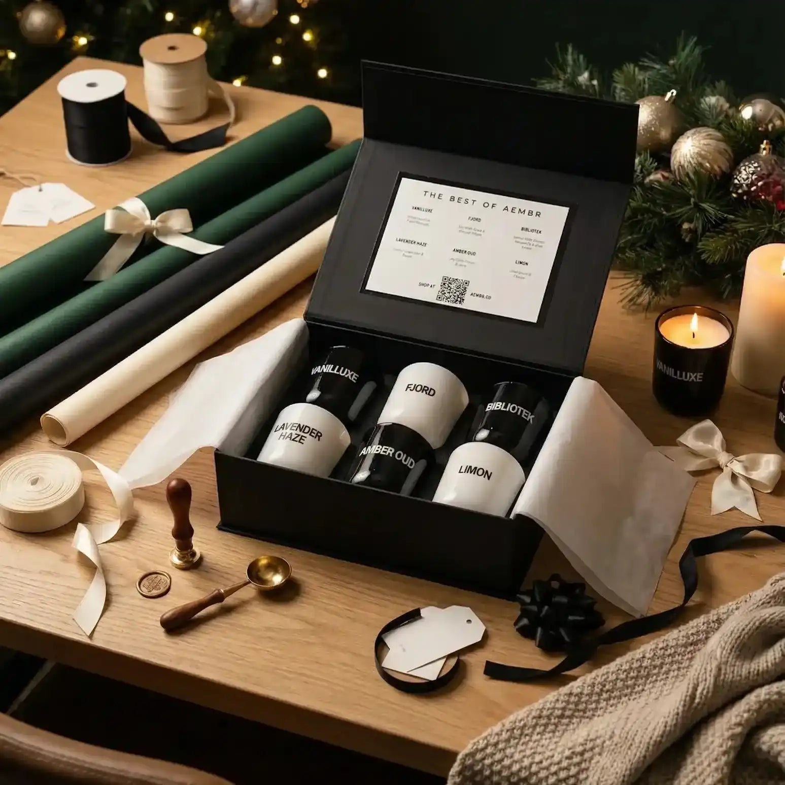 AEMBR scented candle gift set displayed in a festive setting with ribbon, gift tags, and holiday decor.