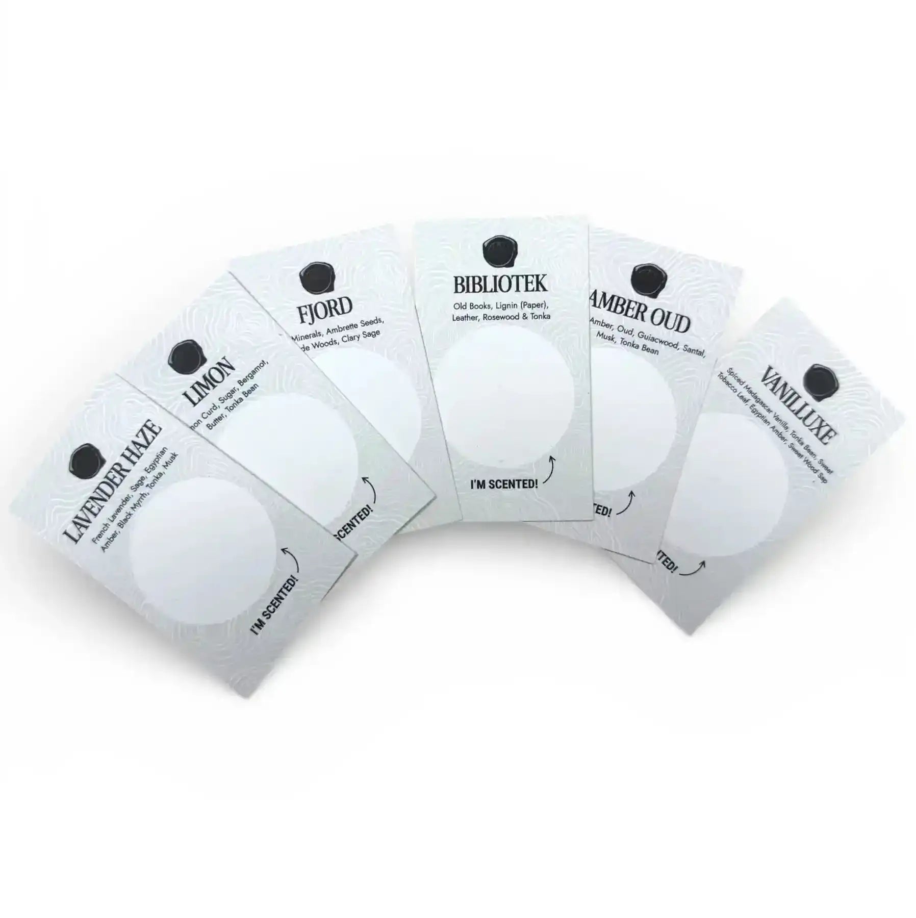 AEMBR scented sample cards for non-toxic candles, featuring fragrances like Lavender Haze, Limon, Fjord, Bibliotek, Amber Oud, and Vaniluxe, displayed in a fanned arrangement.
