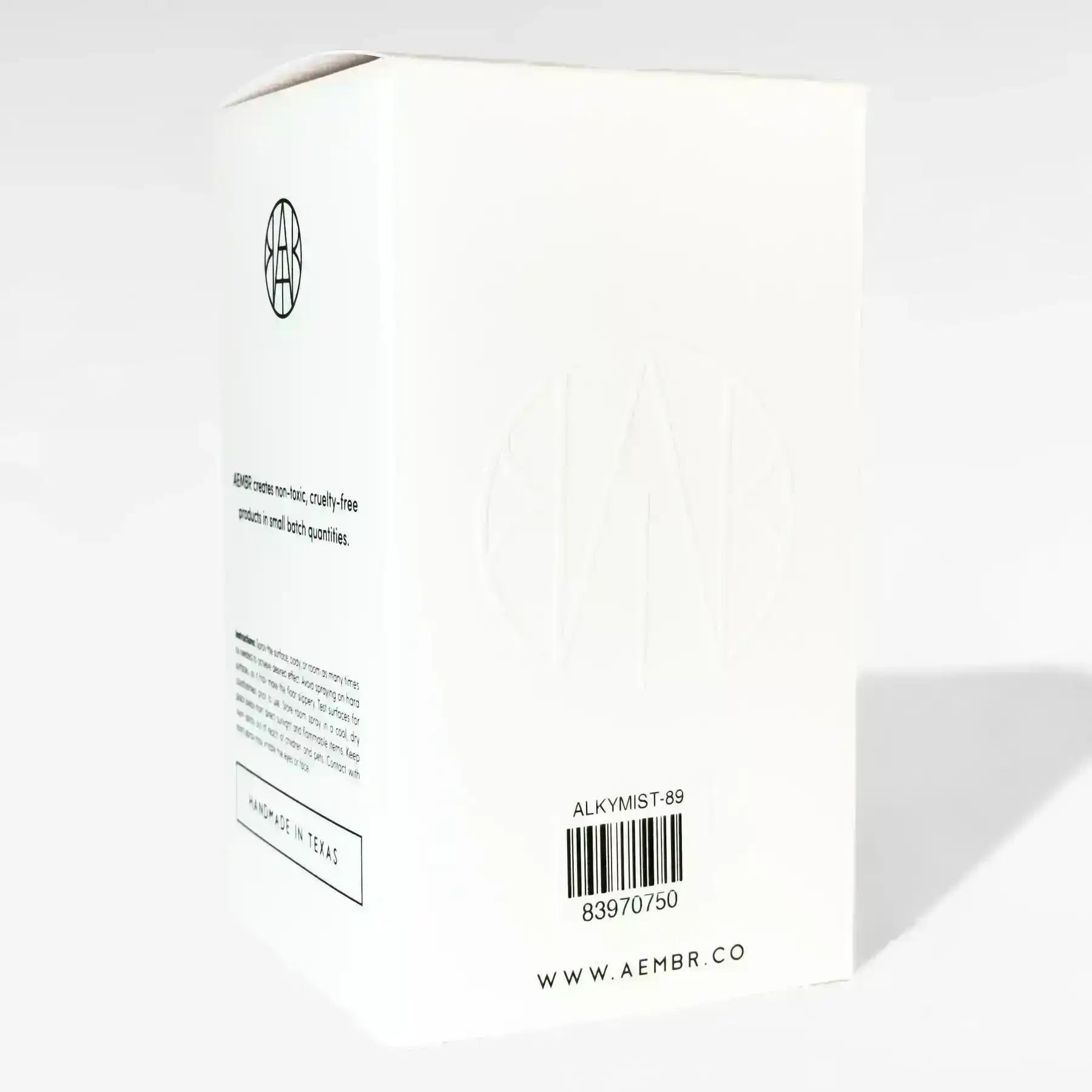 AEMBR non-toxic candle box with minimalist white packaging, barcode, and handmade in Texas label.