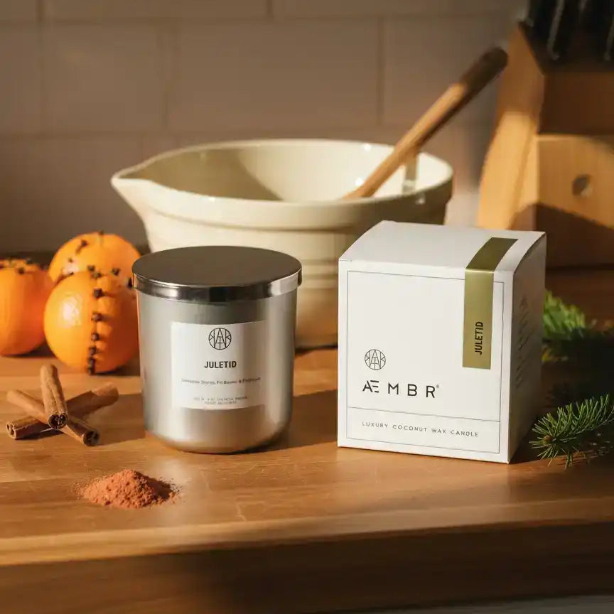 AEMBR Juletid luxury coconut wax candle with festive spices and oranges on a kitchen countertop