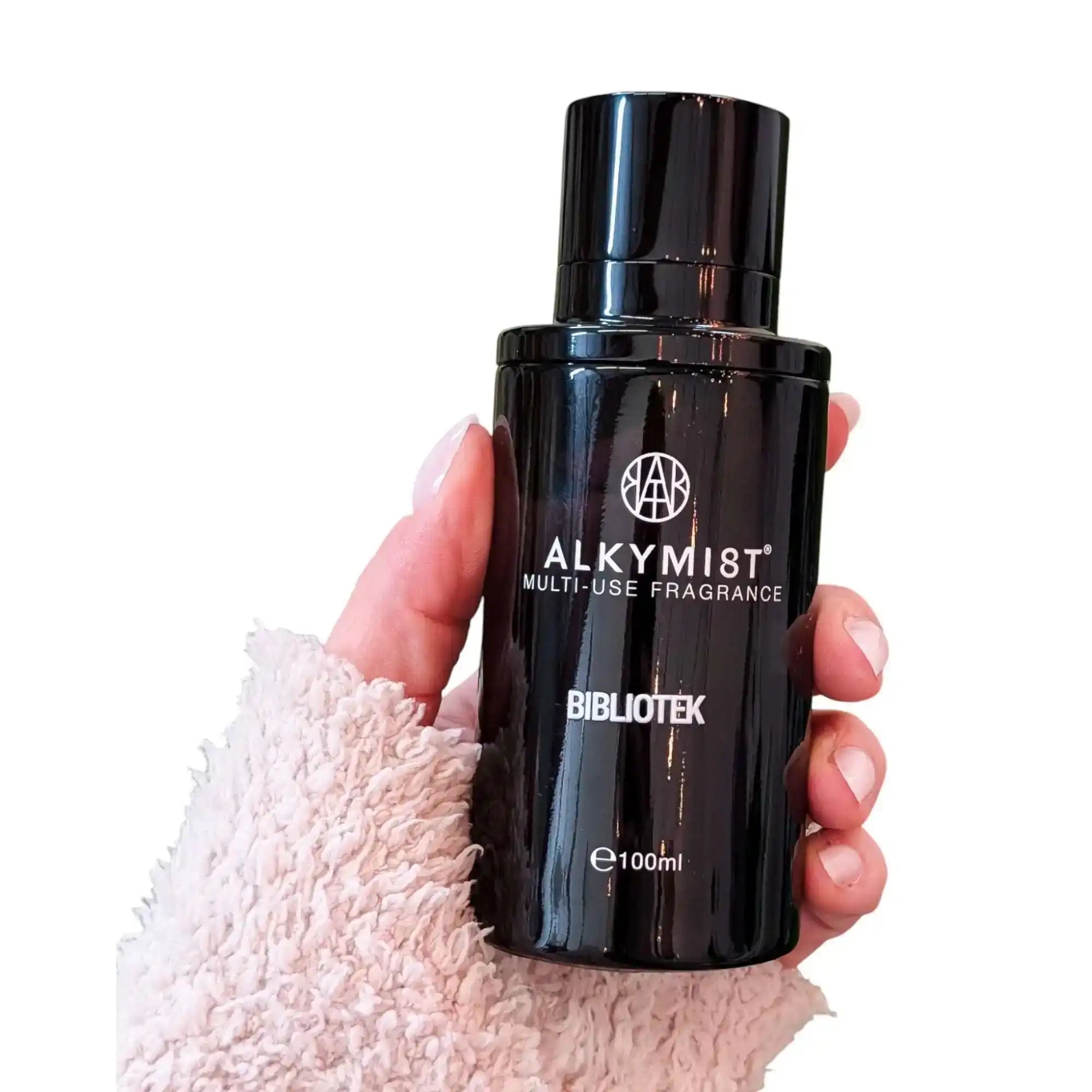 Hand holding ALKYMIST BIBLIOTEK multi-use non-toxic fragrance spray bottle, 100ml