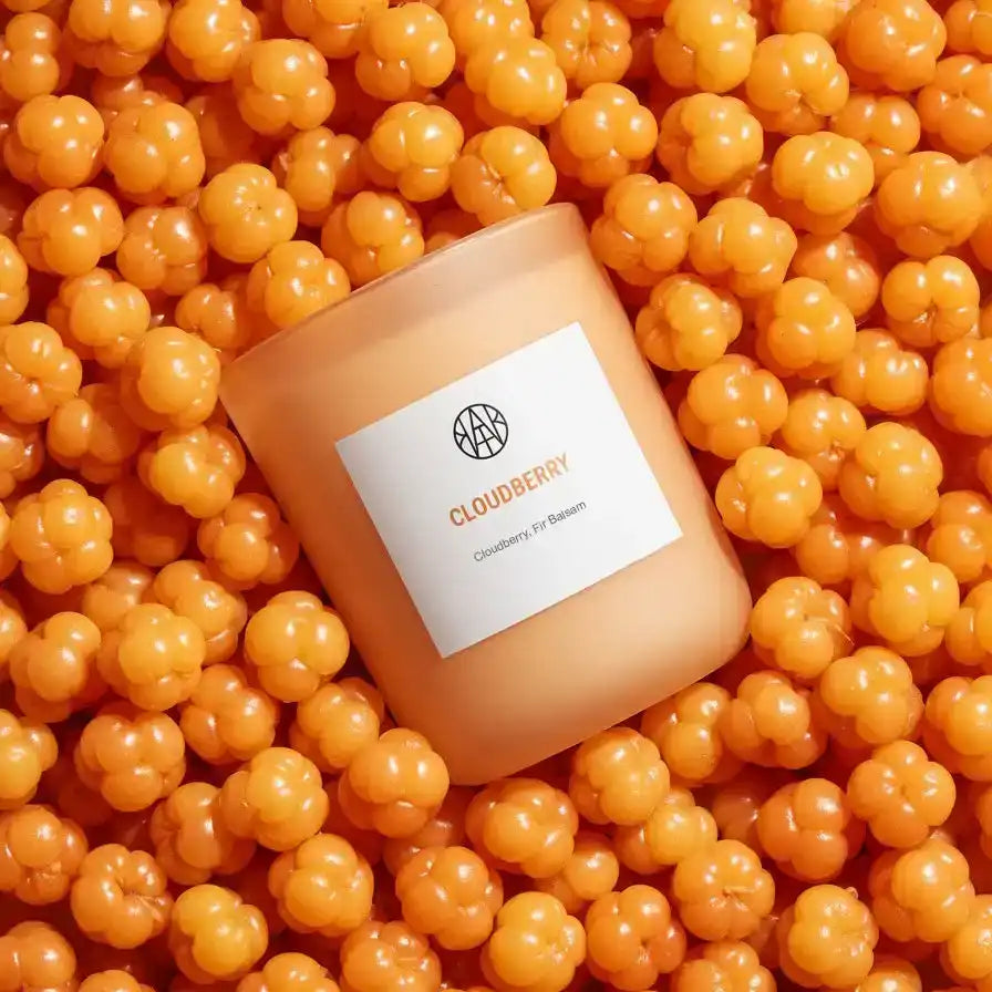 AEMBR Cloudberry candle close-up surrounded by fresh cloudberries, non-toxic home fragrance