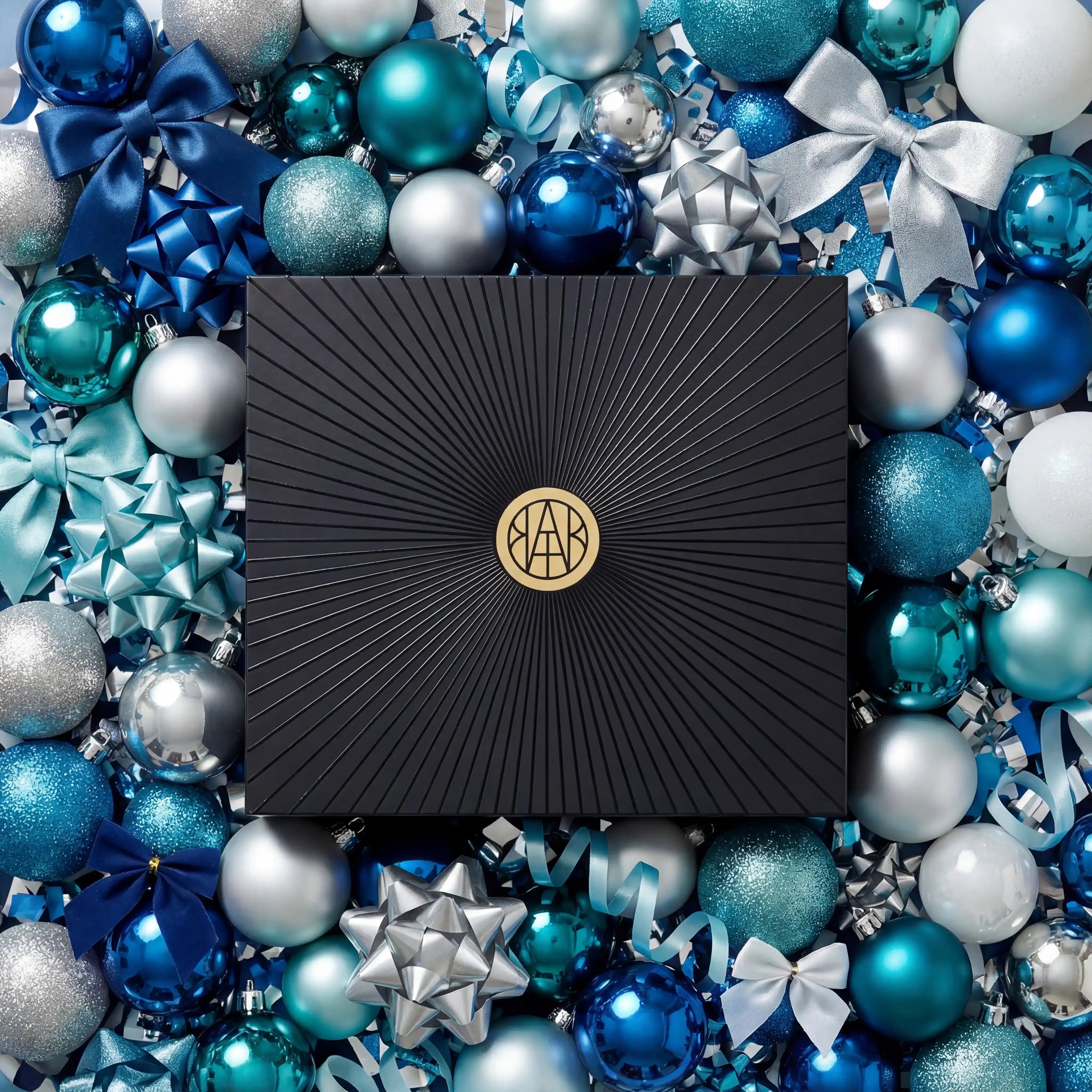 AEMBR gift box surrounded by blue and silver holiday ornaments and bows