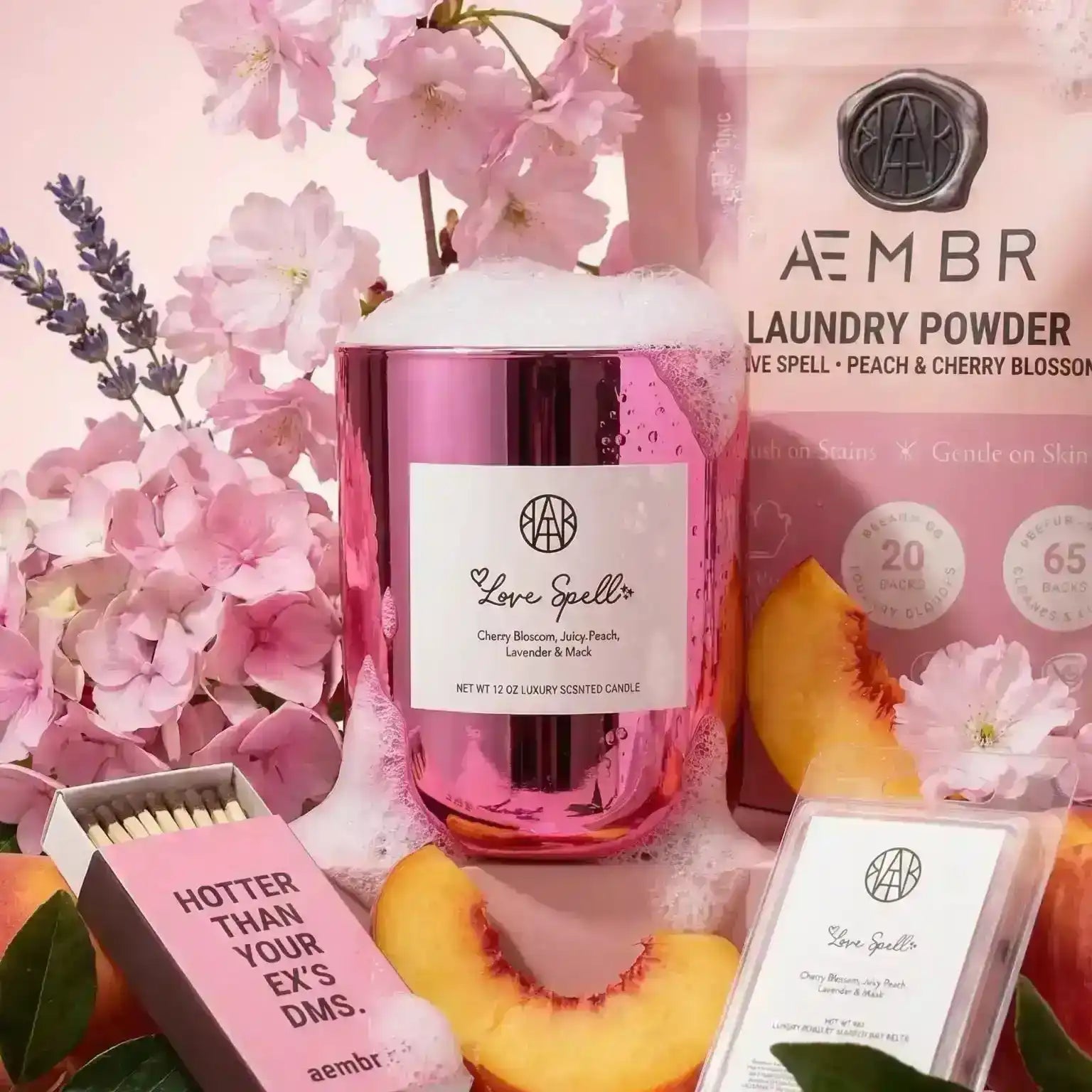 AEMBR Love Spell candle, laundry powder, and wax melt with peaches, cherry blossoms, and pink flowers.