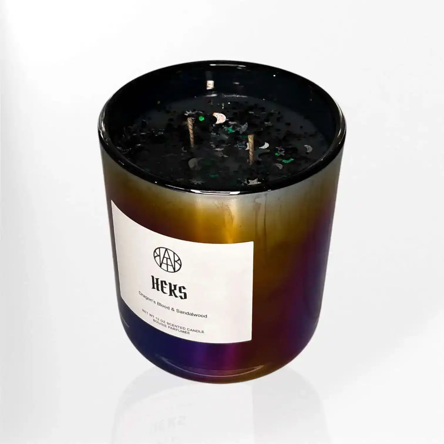 AEMBR Heks Candle, a decorative candle with intricate design, placed on a wooden surface with a warm glow.