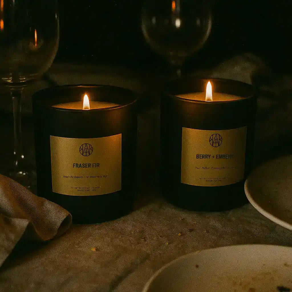 AEMBR Hygge Candle in a glass jar with a lit wick, creating a cozy and warm ambiance.
