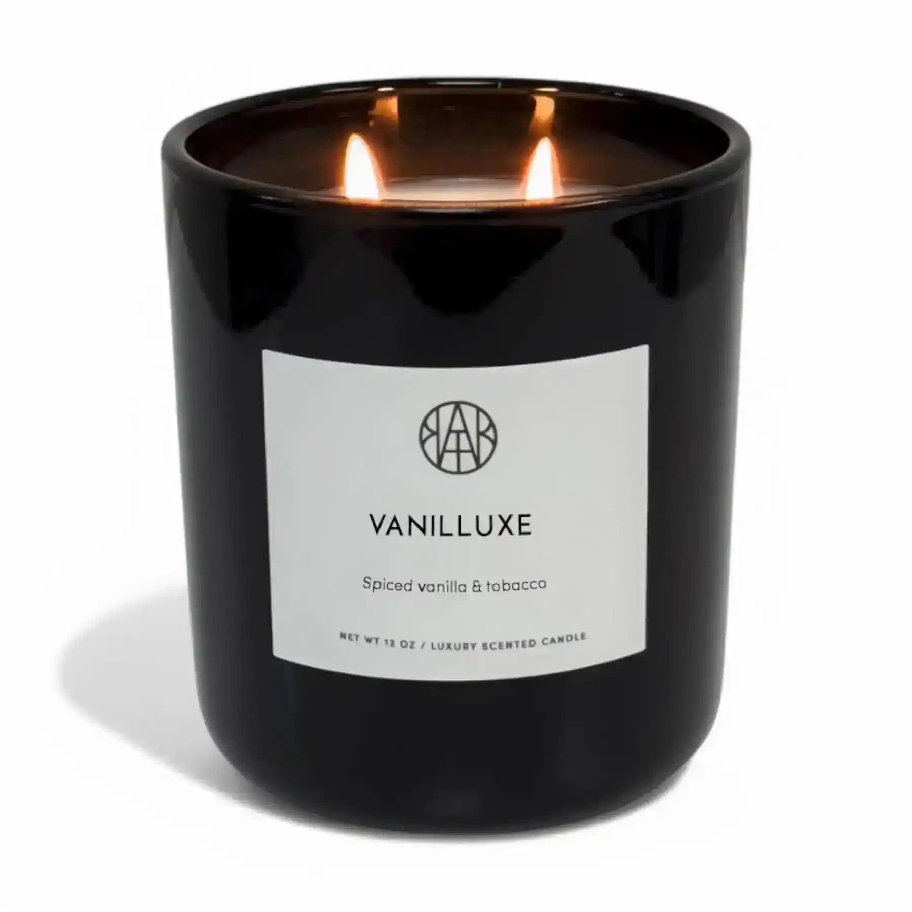 AEMBR Vanilluxe Candle with a sleek glass jar and vanilla scent, burning softly to create a cozy atmosphere.