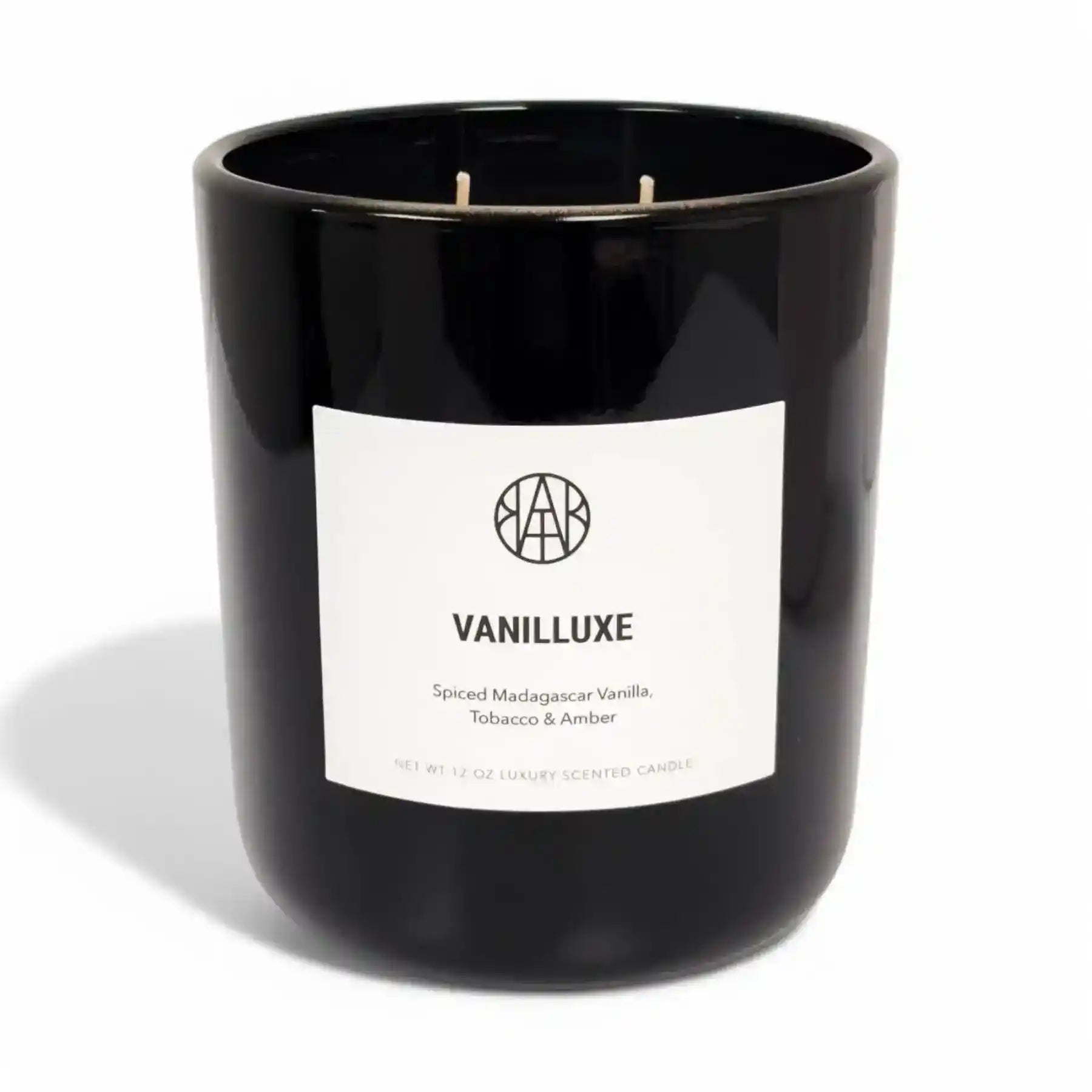 AEMBR Vanilluxe Candle with a sleek glass jar and vanilla scent, featuring a burning wick and soft glow.