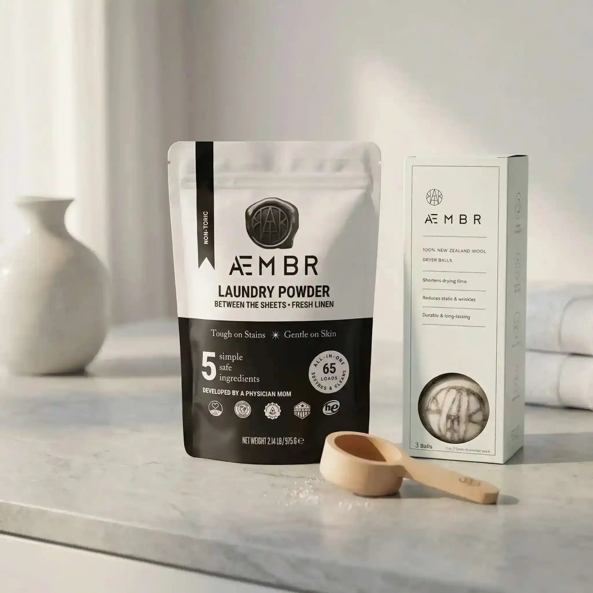 AEMBR non-toxic laundry bundle with natural laundry care products, including bottles and cleaning accessories on a white background.