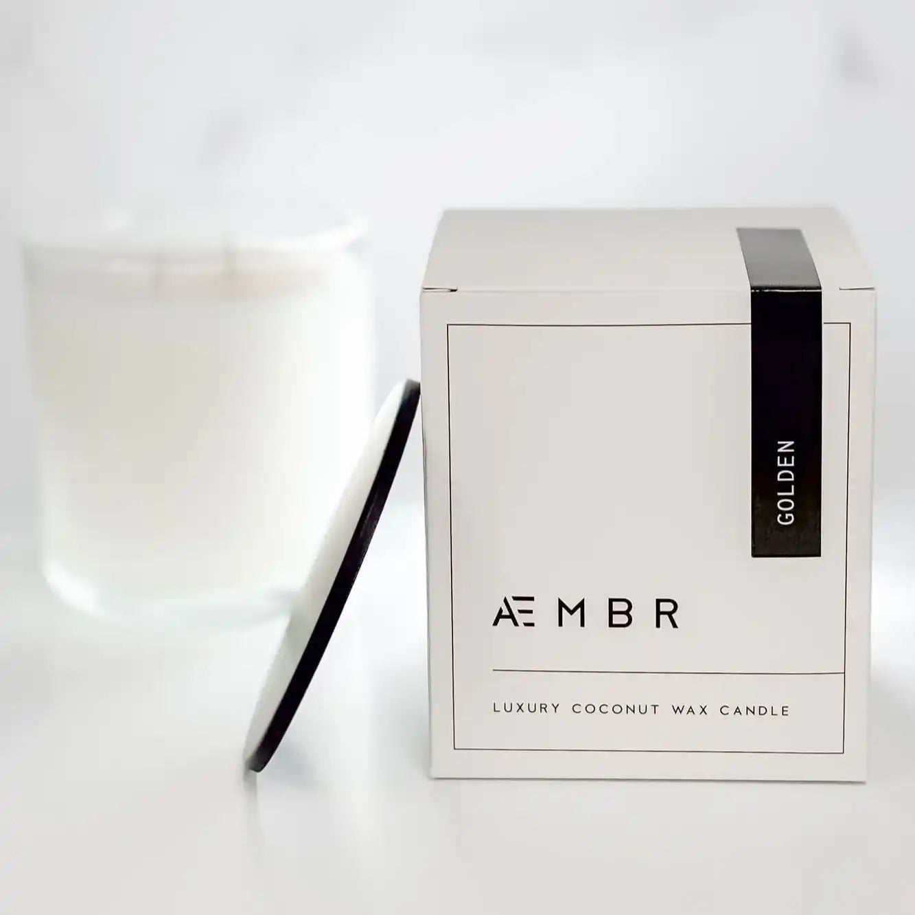 AEMBR luxury coconut wax candle with double wick, black lid, and branded white box