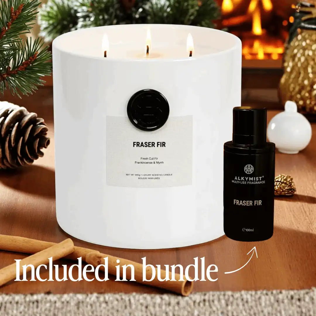 AEMBR Fraser Fir candle and fragrance bundle on a wooden table with pinecone and fireplace decor.