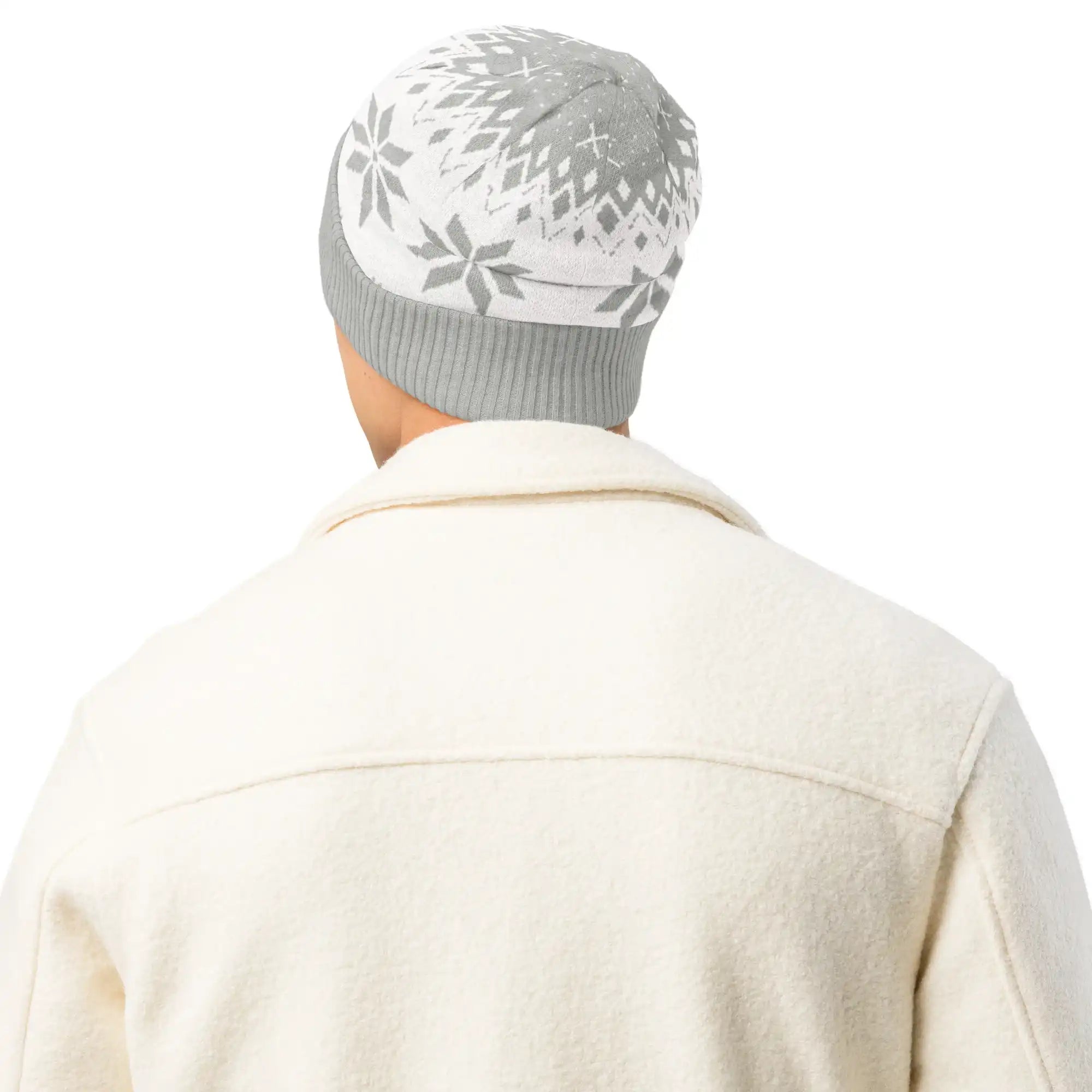 AEMBR grey and white knitted beanie with snowflake pattern, worn with a cream jacket