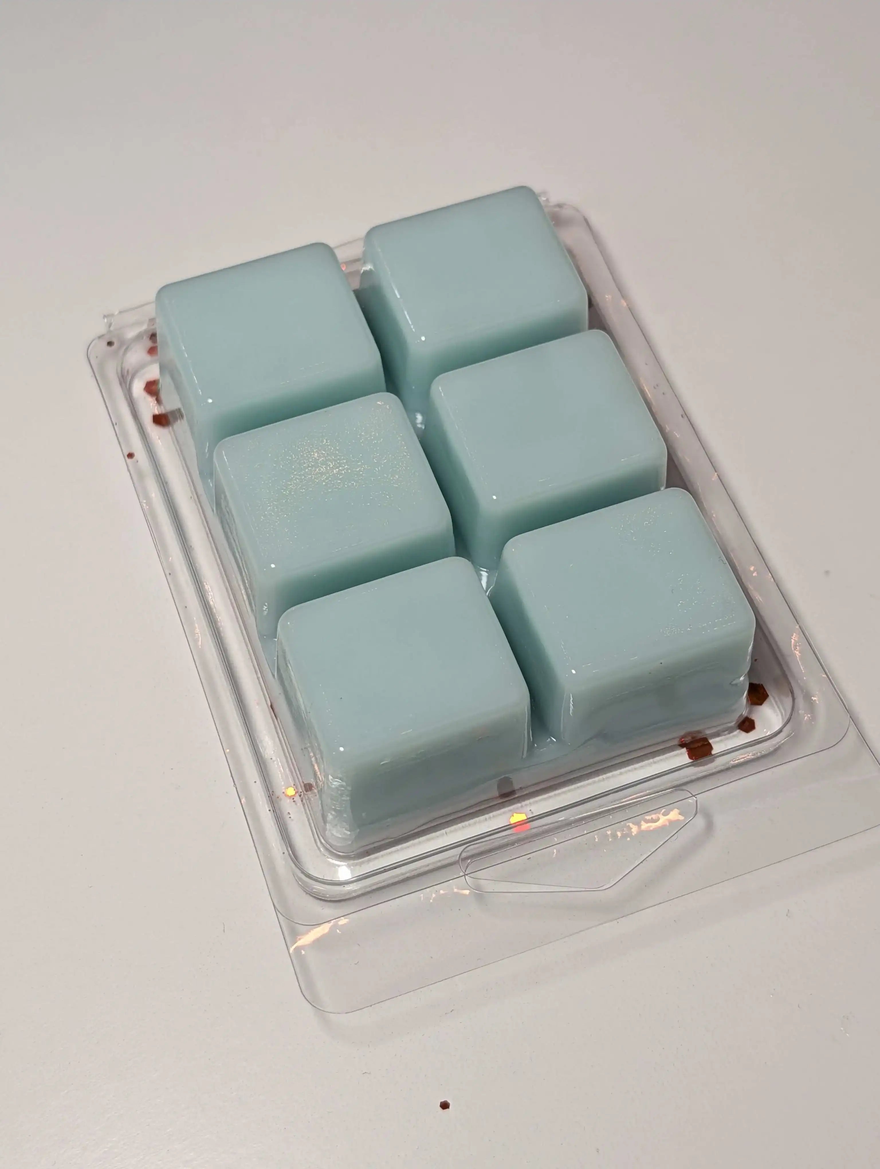 AEMBR non-toxic blue wax melts in plastic clamshell packaging on a white surface