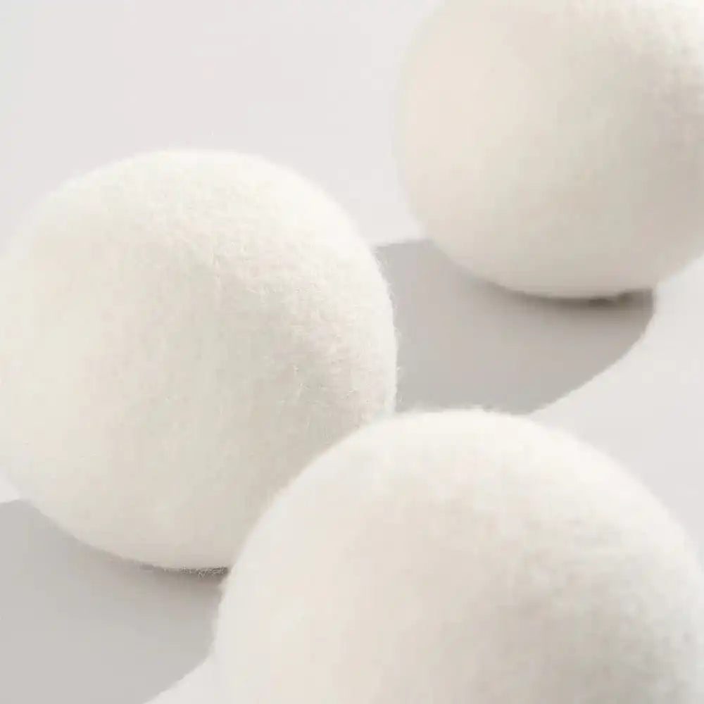 AEMBR white wool dryer balls on a bright surface, non-toxic home care product