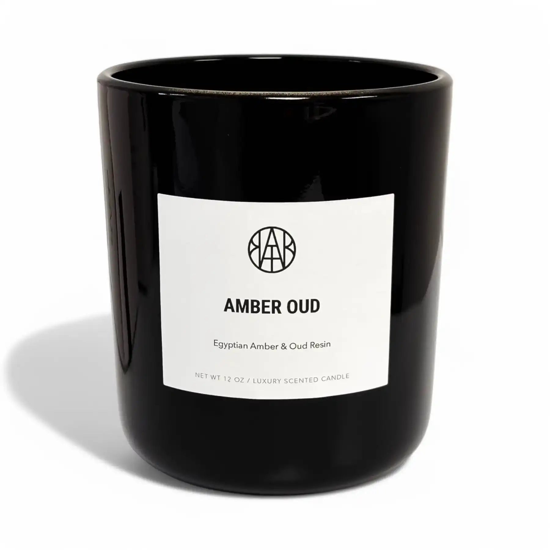 AEMBR Amber Oud luxury scented candle in a sleek black glass jar with white minimalist label.