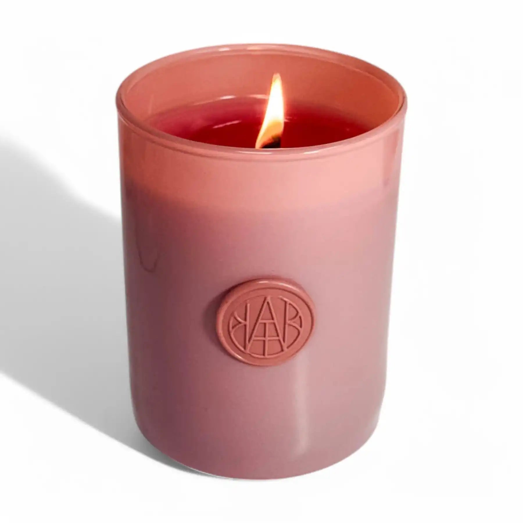 AEMBR scented candle in a pink glass jar with wooden wick, clean home fragrance product