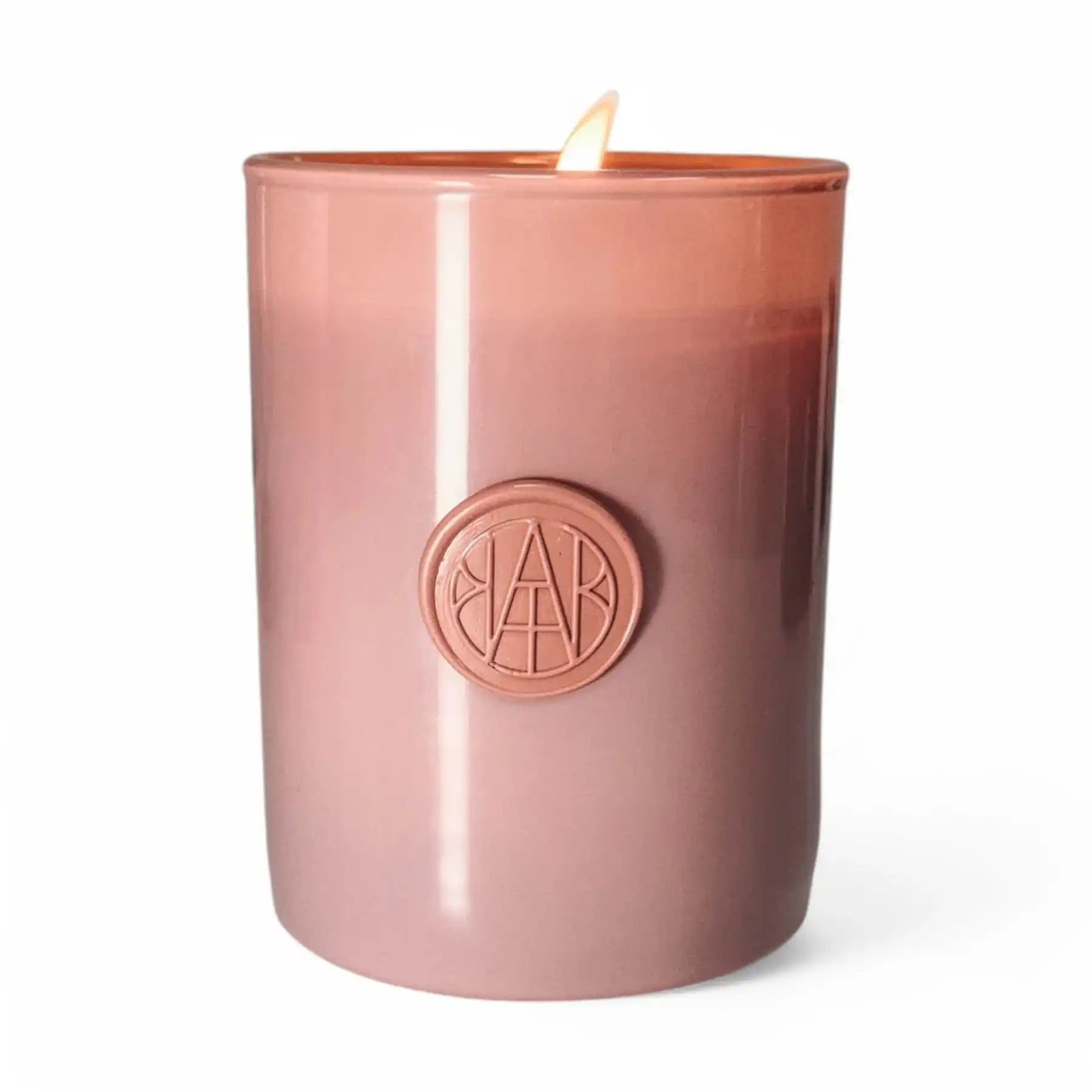 Non-toxic wooden wick candle in rose glass jar with embossed seal, lit, on white background