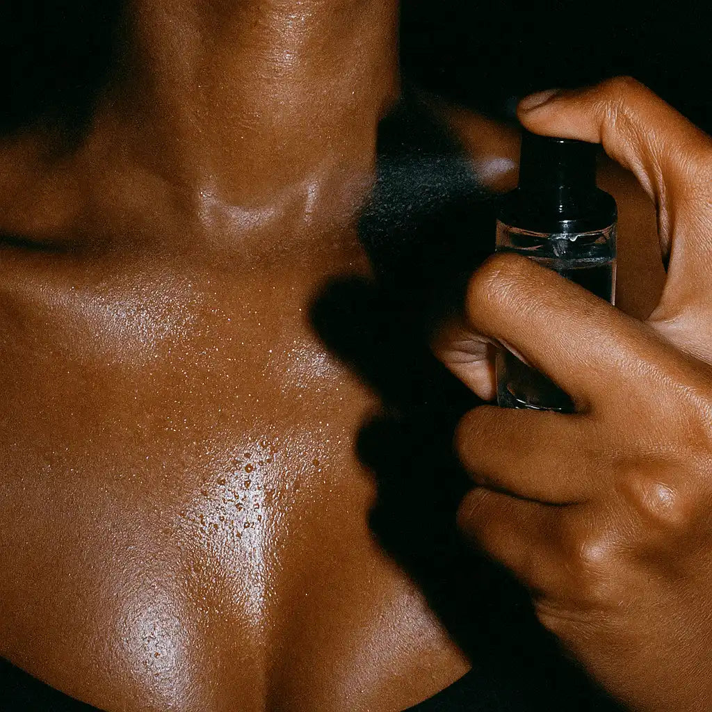 Person spraying non-toxic fragrance mist on skin, close-up of neck and chest
