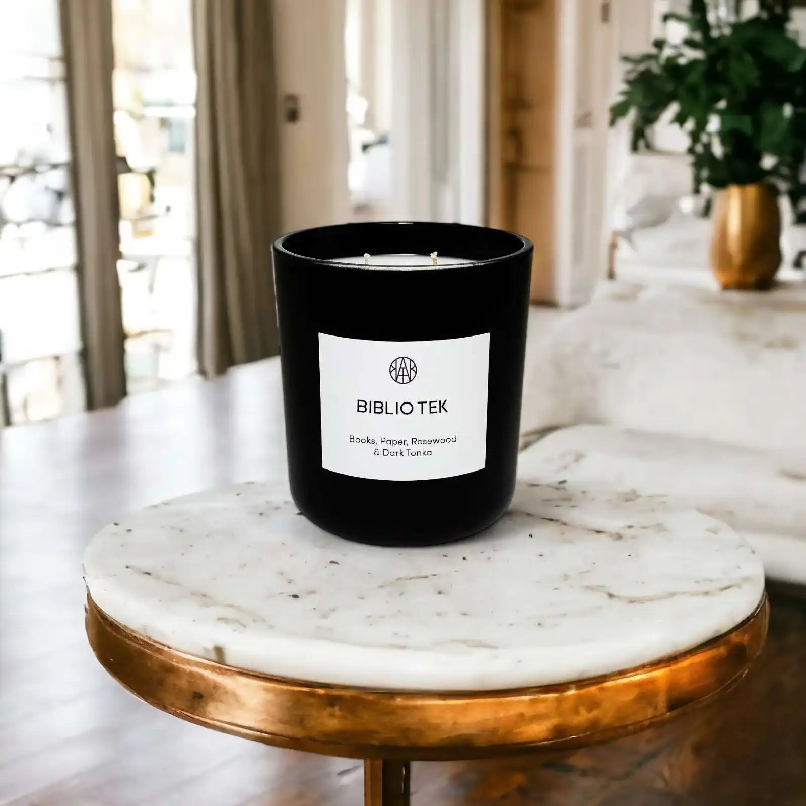 AEMBR Biblio Tek candle with black glass jar on marble table, modern living room background