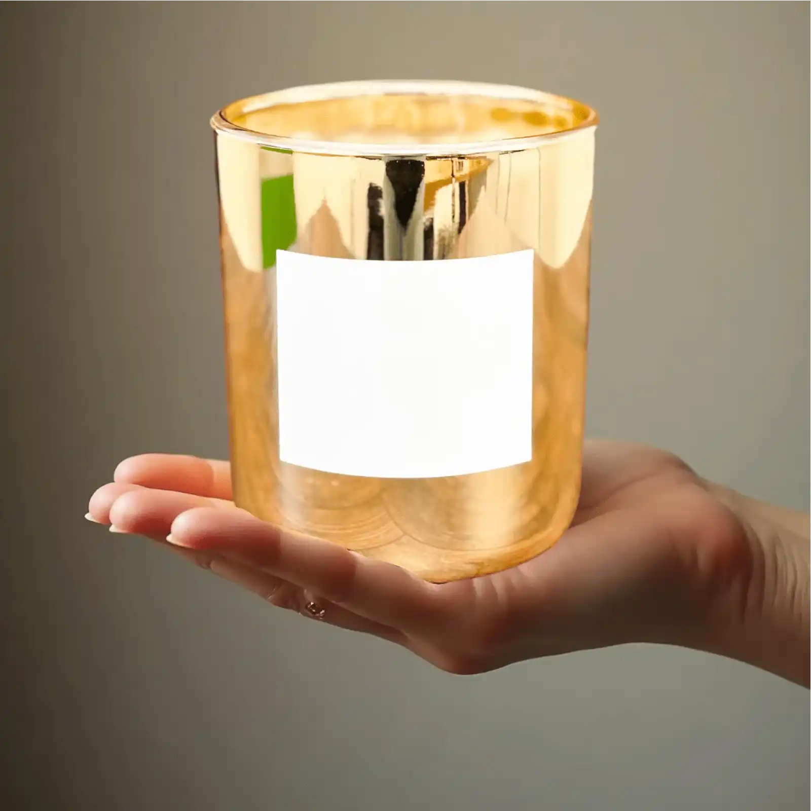 AEMBR gold candle in a hand, non-toxic home fragrance, elegant minimalist design