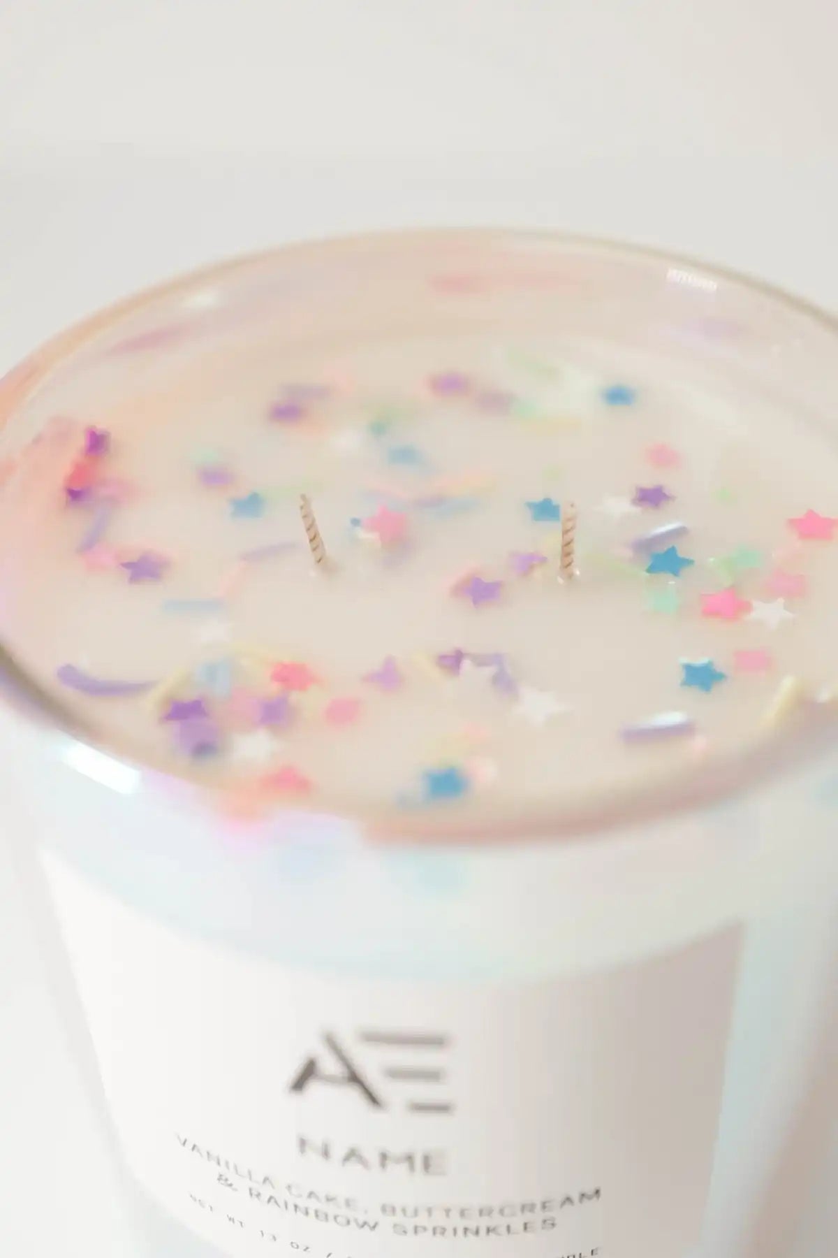 Non-toxic vanilla cake candle with buttercream scent and rainbow star sprinkles in wax