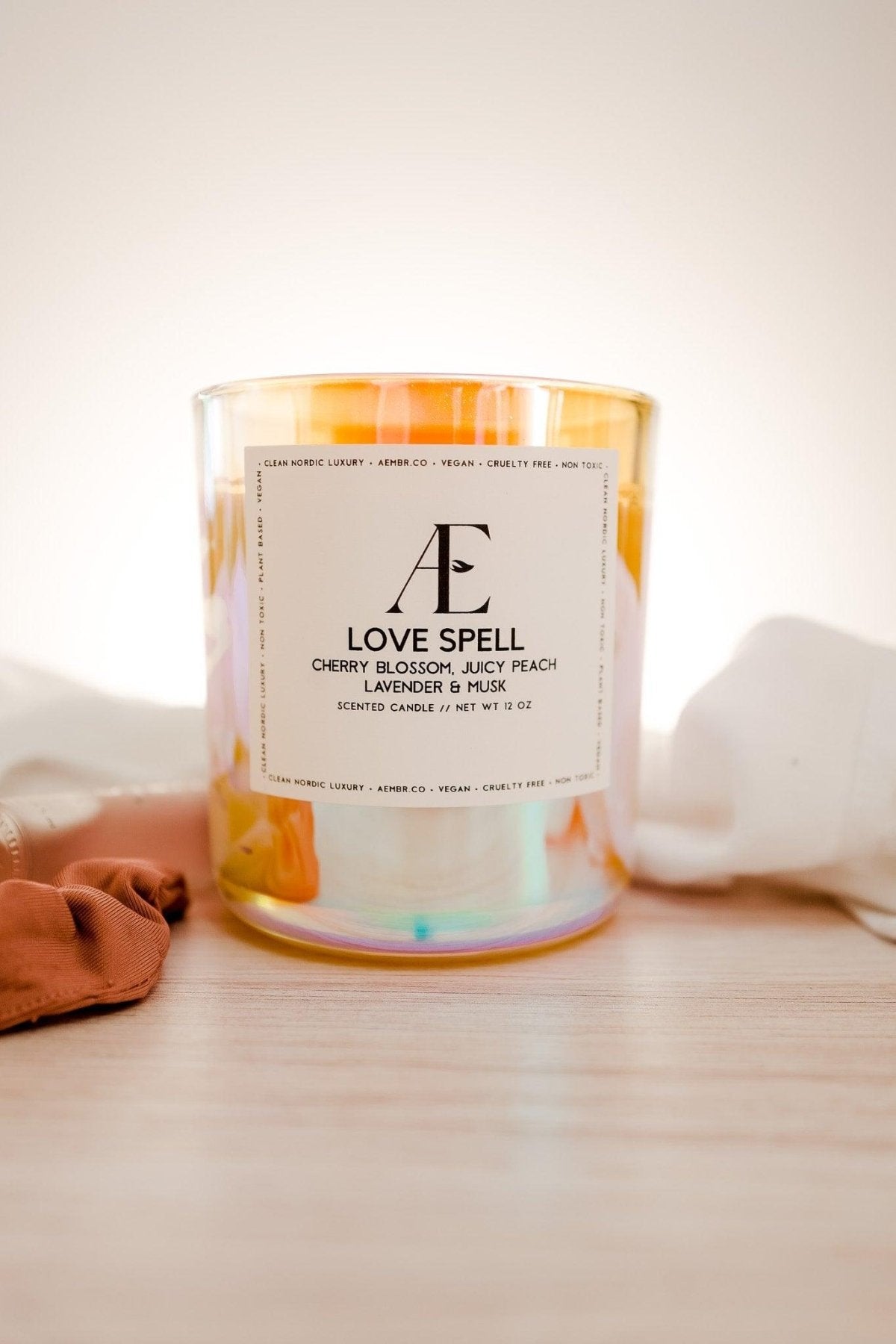 Non-toxic Love Spell scented candle in iridescent glass jar on wooden surface