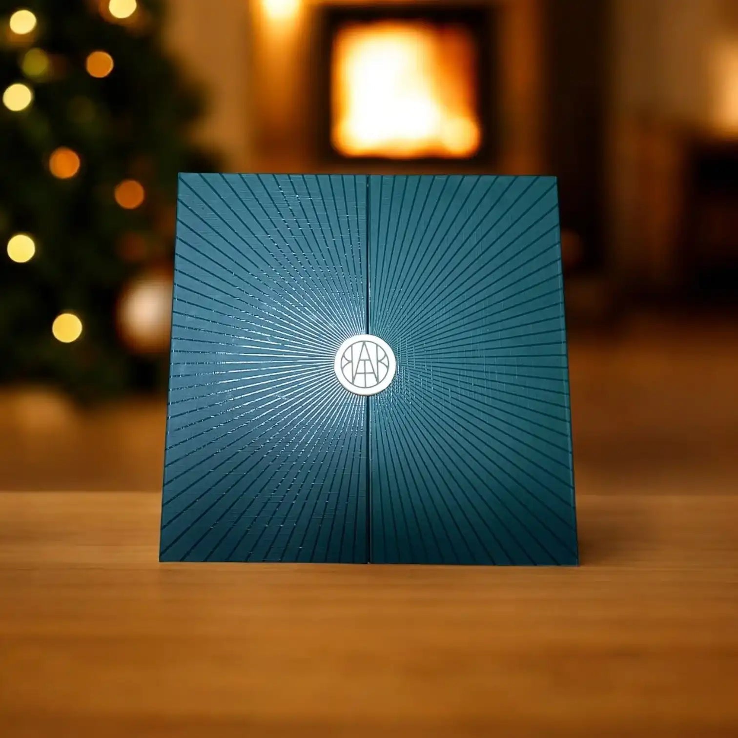 AEMBR luxury advent calendar box on a wooden table with fireplace and holiday lights background