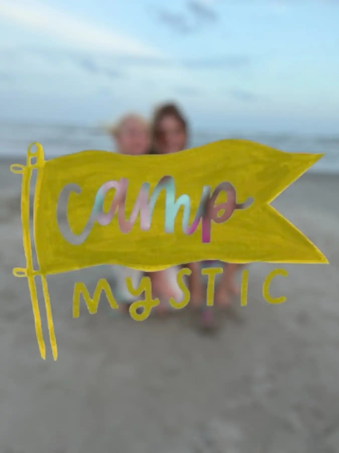 Hand-drawn yellow Camp Mystic flag on a sandy beach, AEMBR non-toxic lifestyle theme