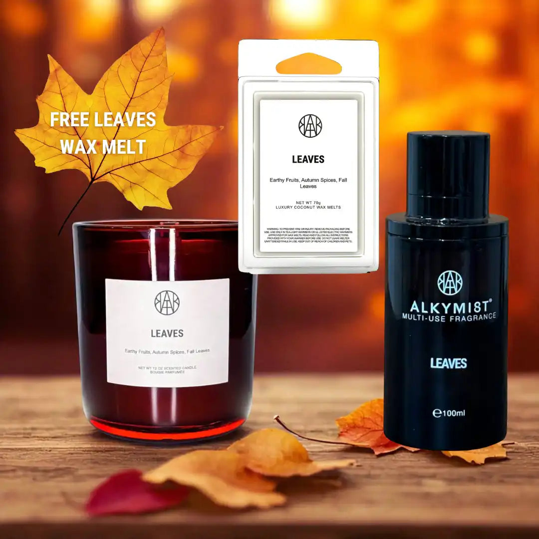 AEMBR Leaves scented candle, wax melt, and fragrance spray with autumn leaves on a wooden surface.