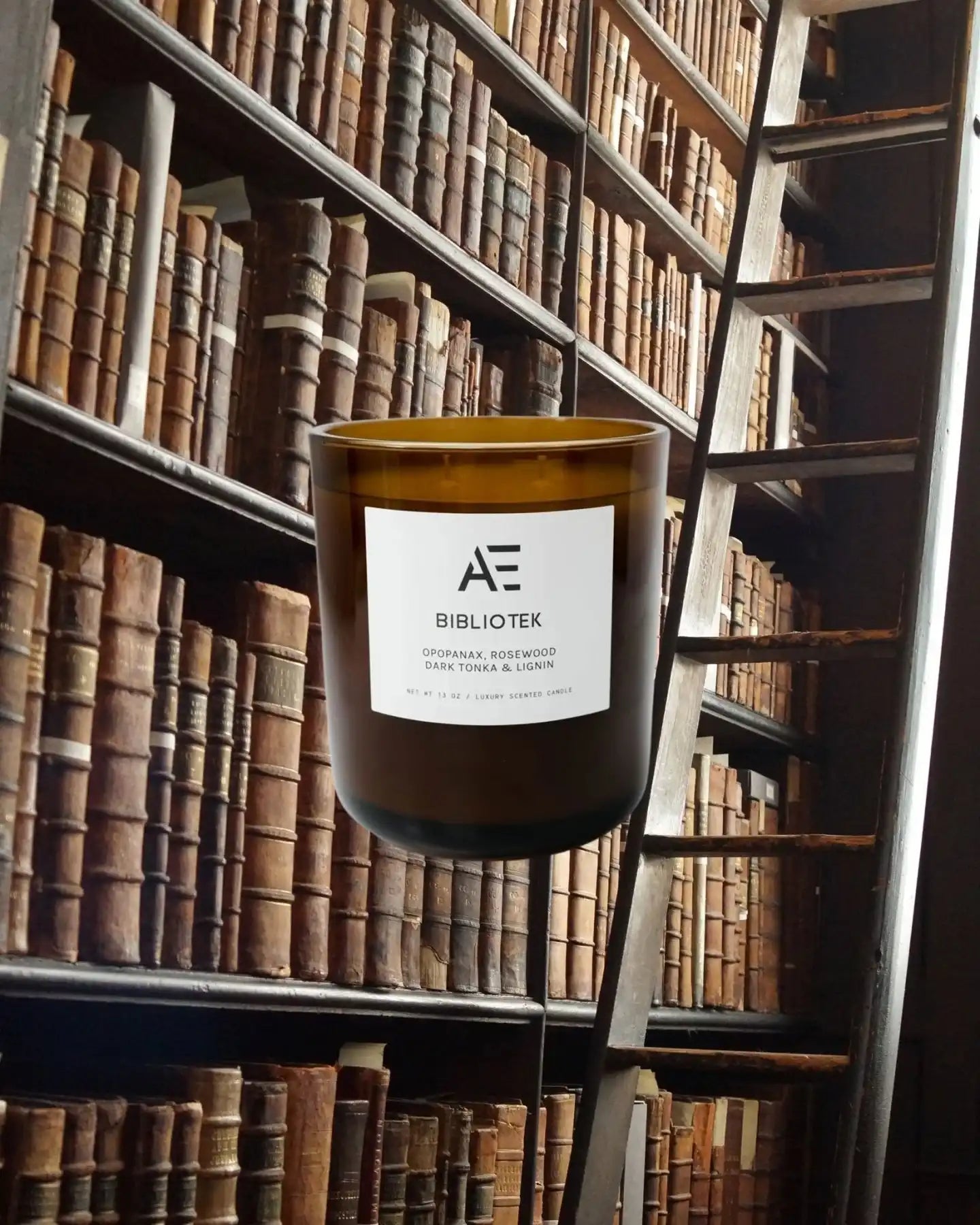 AEMBR Bibliotek scented candle in glass jar with vintage library books and ladder background