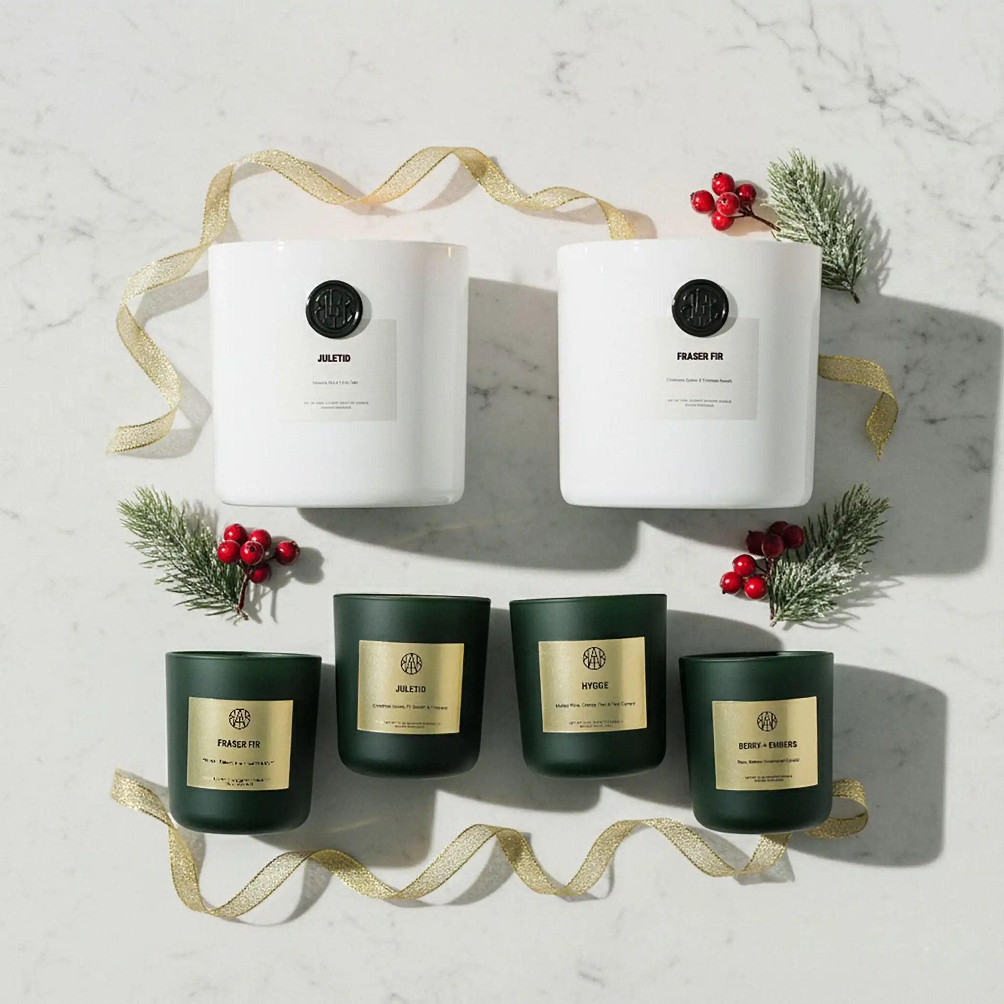 AEMBR non-toxic candles in white and green glass jars, holiday decor, on marble background