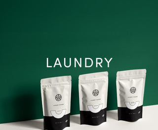 set of three aembr laundry powders against a signature green background