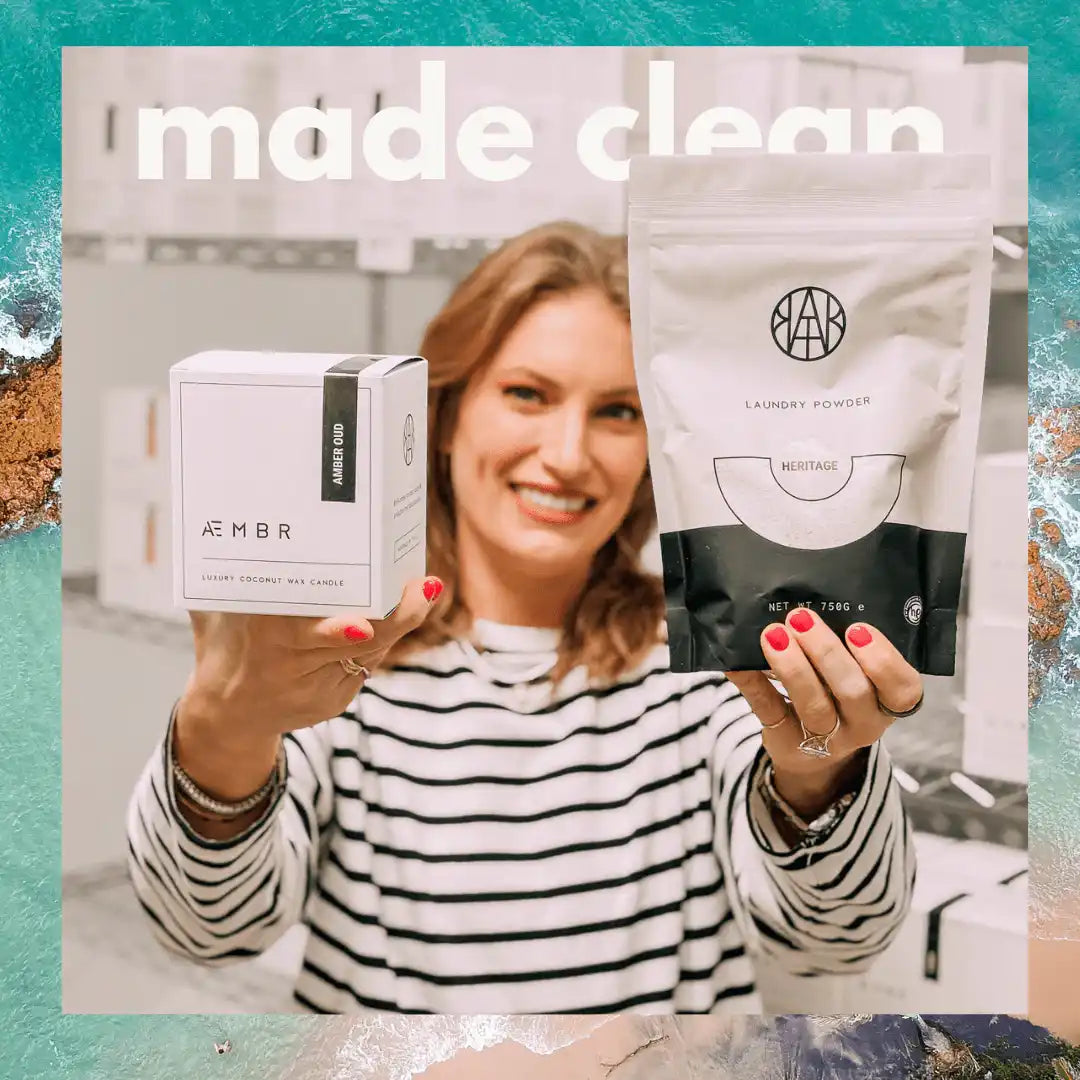 Woman holding AEMBR non-toxic laundry powder and luxury coconut wax candle, clean home products