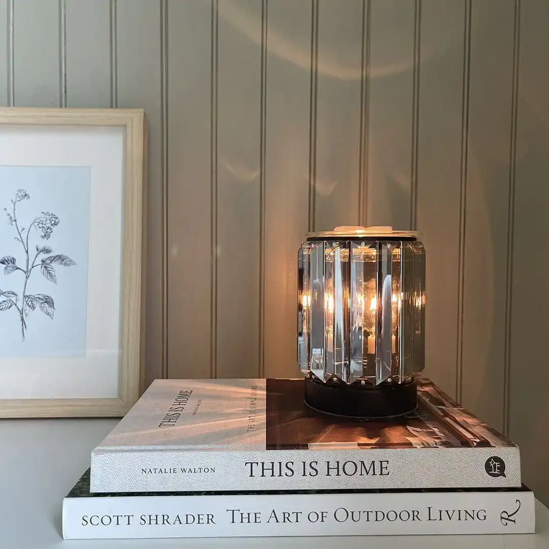Crystal candle warmer lamp on stacked books, home decor setting, non-toxic living by AEMBR