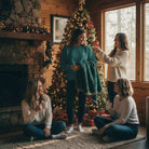 Four women enjoy a cozy holiday setting by a Christmas tree and fireplace, AEMBR lifestyle