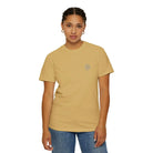 Woman wearing AEMBR beige t-shirt with small chest logo, paired with blue jeans, on white background.