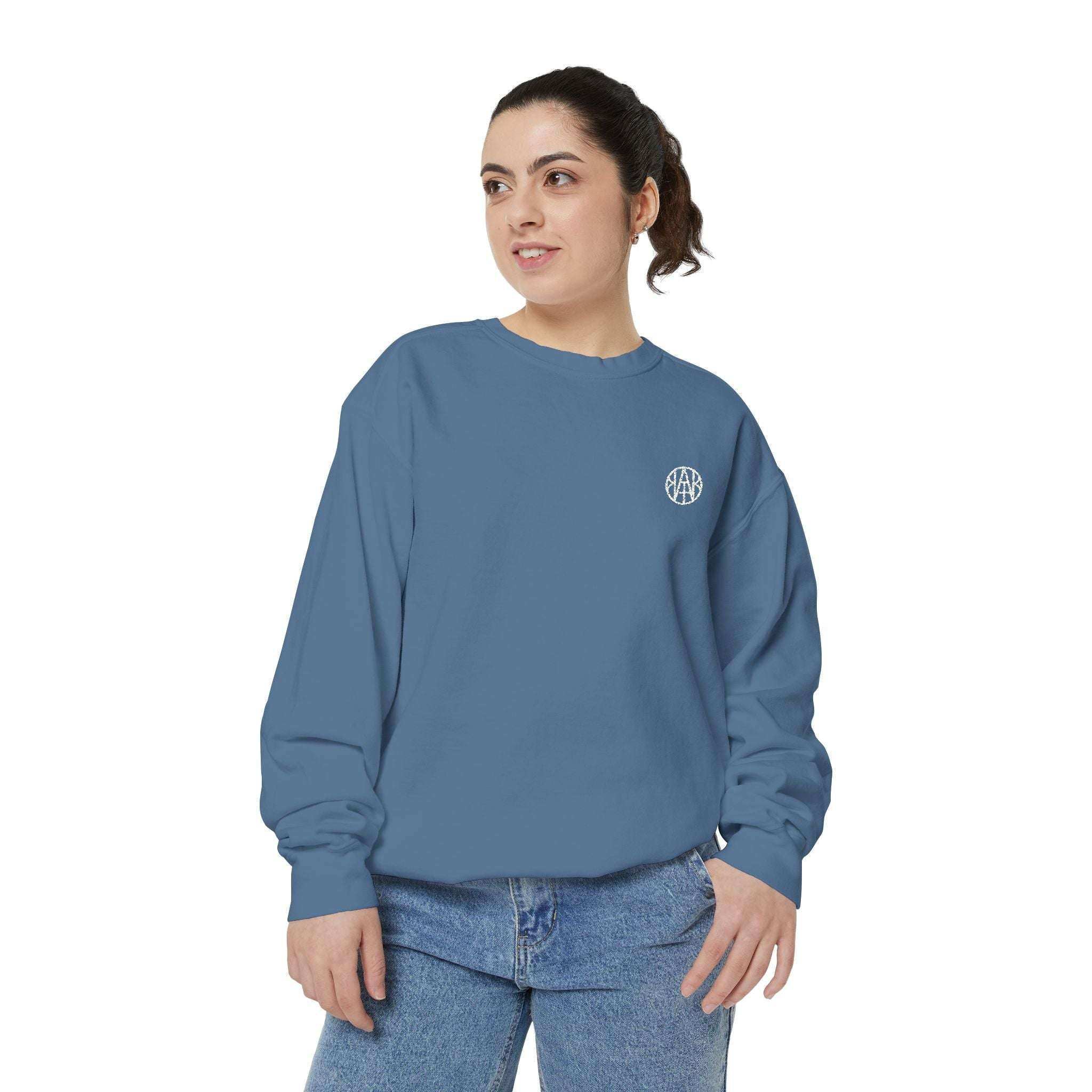 Woman wearing a blue AEMBR sweatshirt with logo, casual style, white background