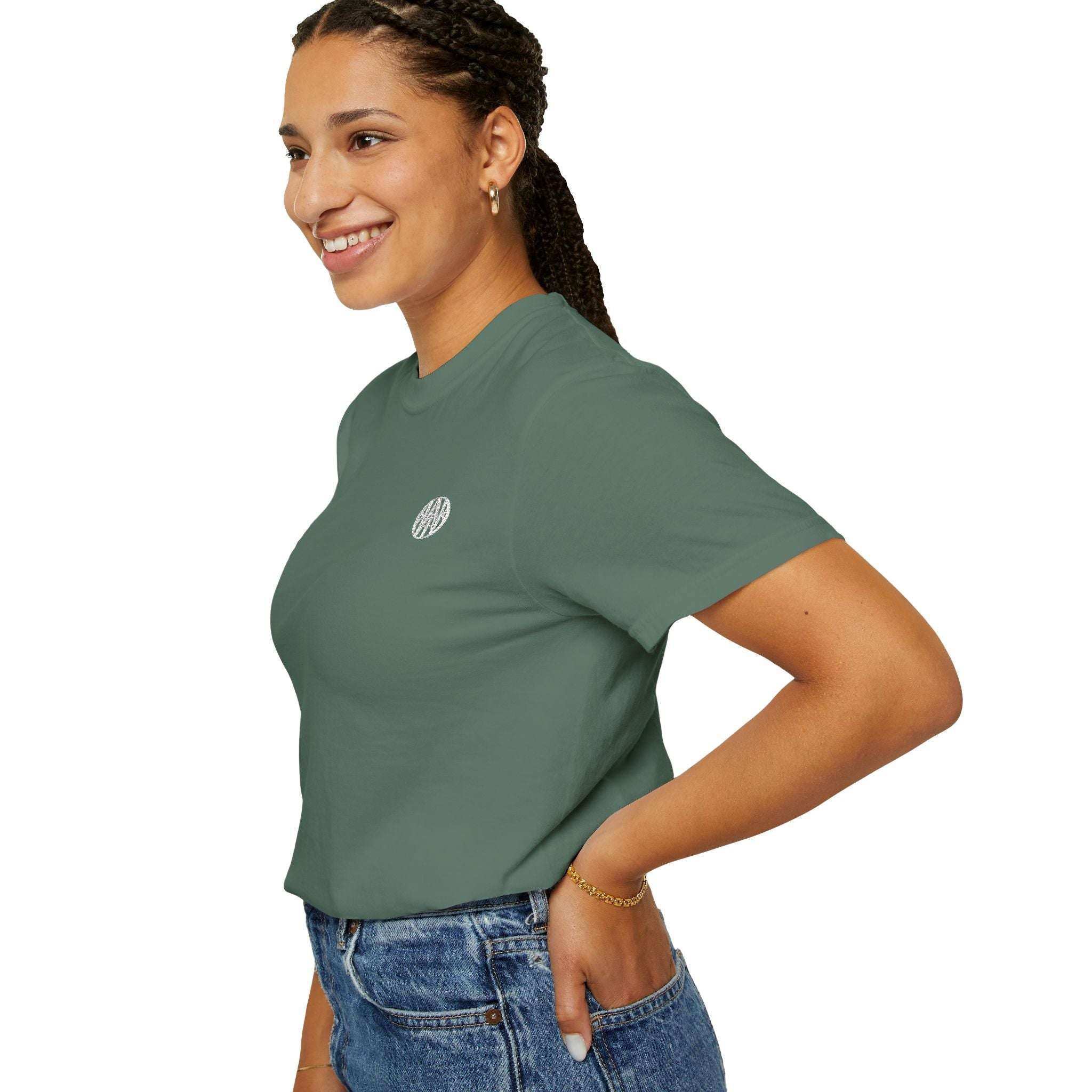 Smiling woman wearing green AEMBR logo t-shirt and jeans on white background