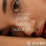 Close-up of a resting woman's face with AEMBR branding and text promoting safe, natural home scents.