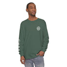 Man wearing AEMBR green long sleeve shirt with logo on chest and branding on sleeve