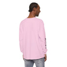Man wearing light pink AEMBR long-sleeve shirt with logo on sleeve, light jeans