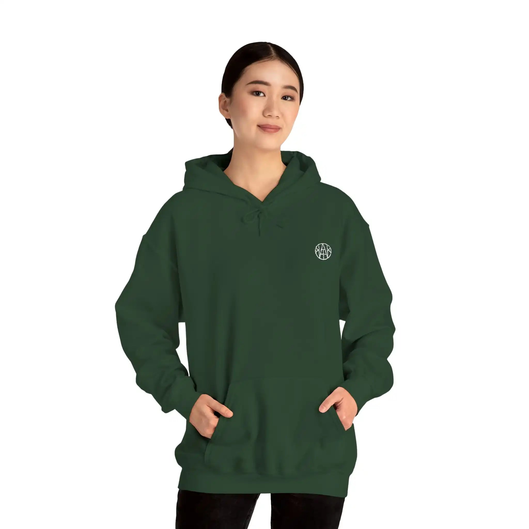 Woman wearing a dark green AEMBR hoodie with logo, hands in pocket, against white background