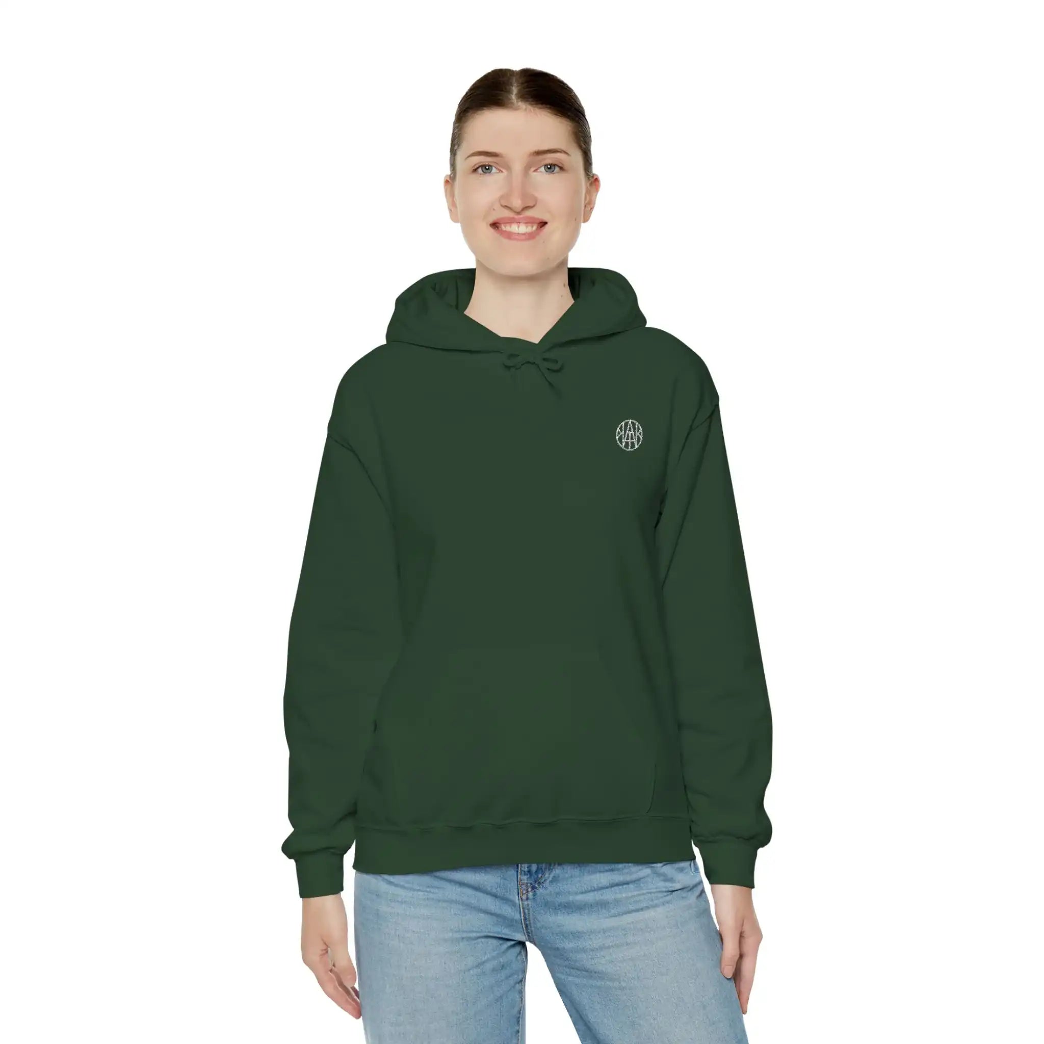 Woman wearing a dark green AEMBR logo hoodie and blue jeans on white background.
