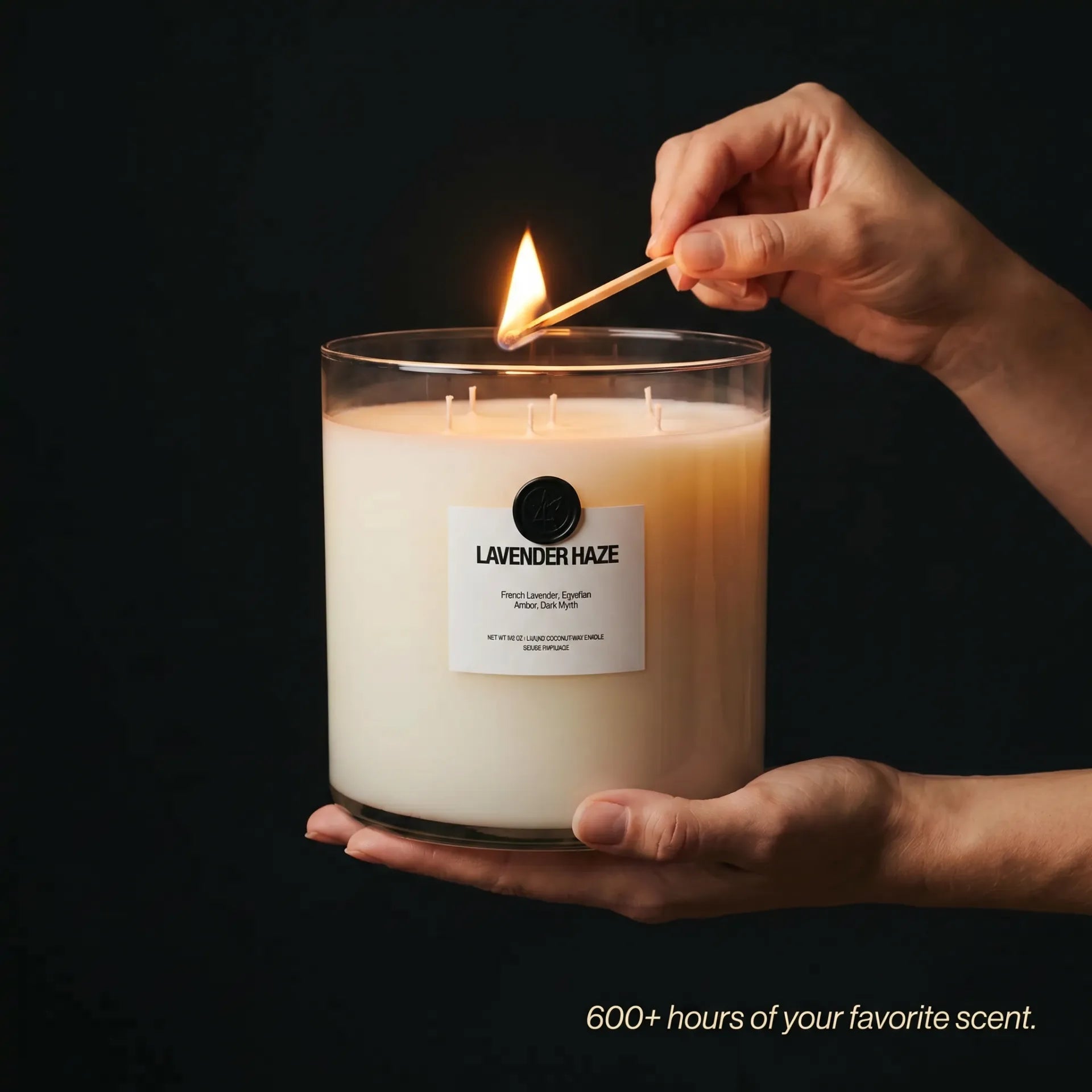 AEMBR Valkyrie Lavender Haze candle in a sleek glass holder with a burning lavender-colored wax, emitting a soft glow.