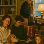 Family reading with golden retriever in cozy living room, autumn candle on side table