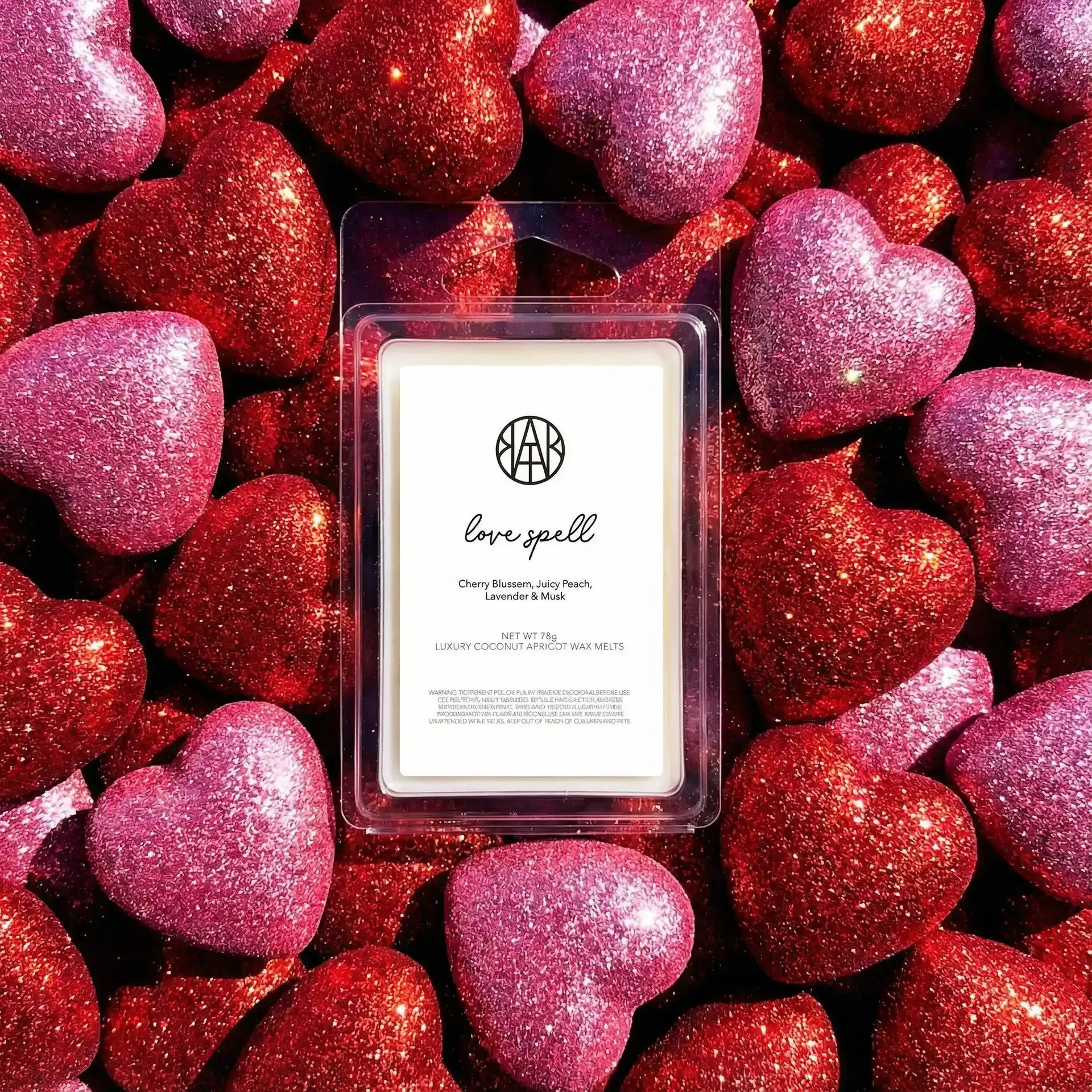 AEMBR Love Spell wax melts on glittery red and pink heart background, luxury home fragrance