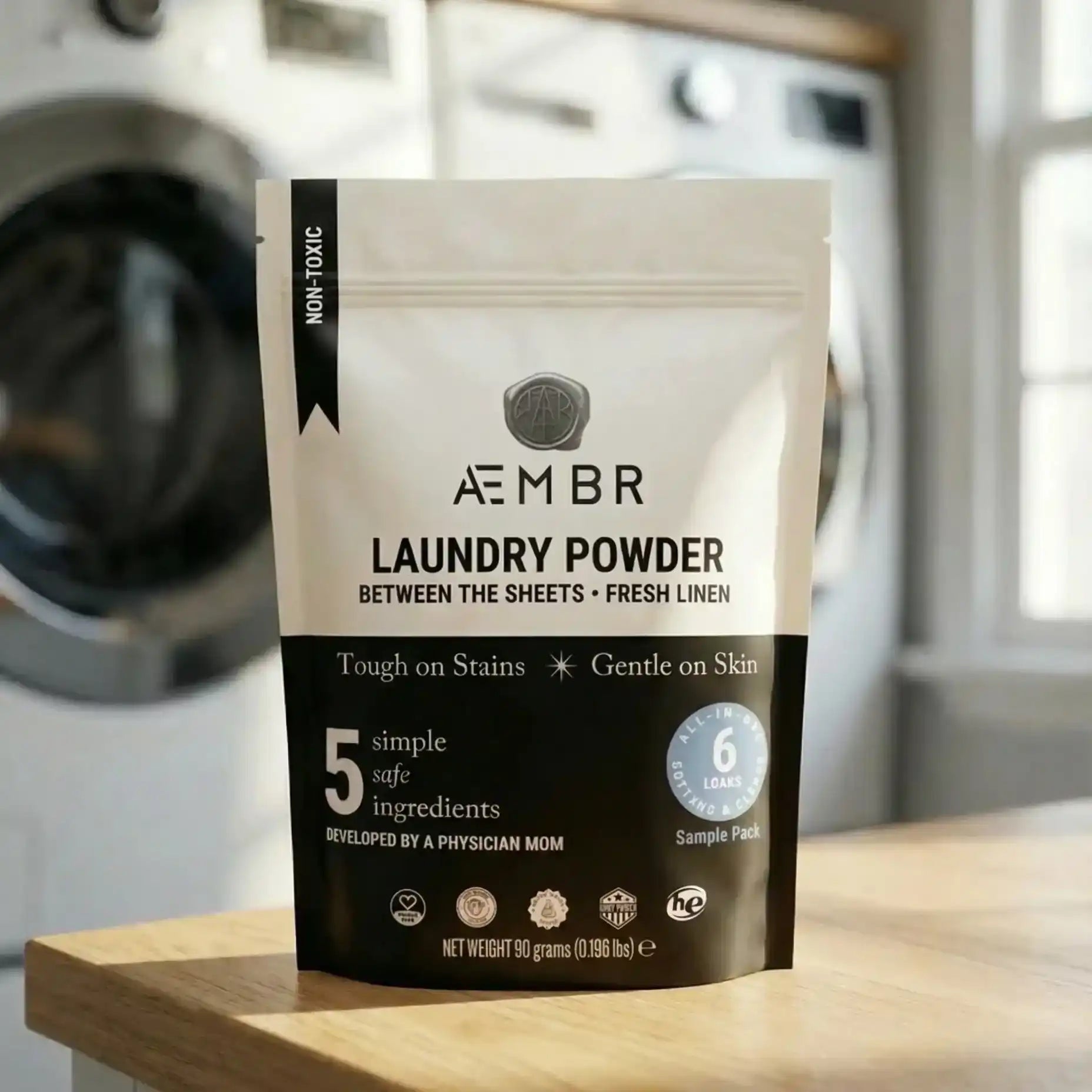 AEMBR Between the Sheets trial pack non-toxic laundry powder on wood table in laundry room